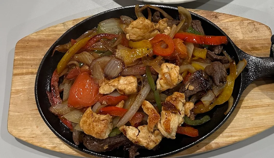 Sizzling fajitas served on a cast iron skillet