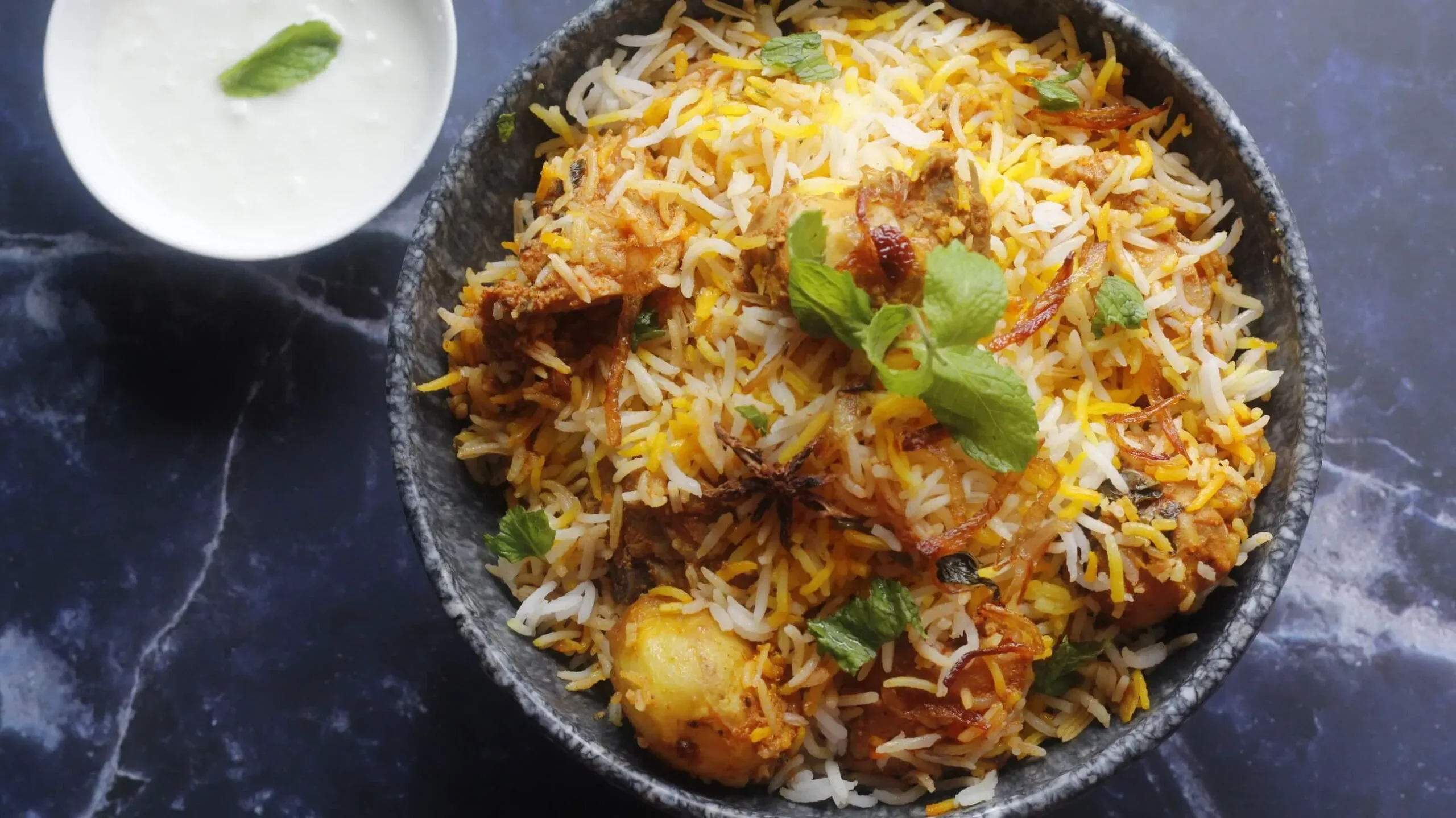 Authentic Indian biryani served with yogurt sauce