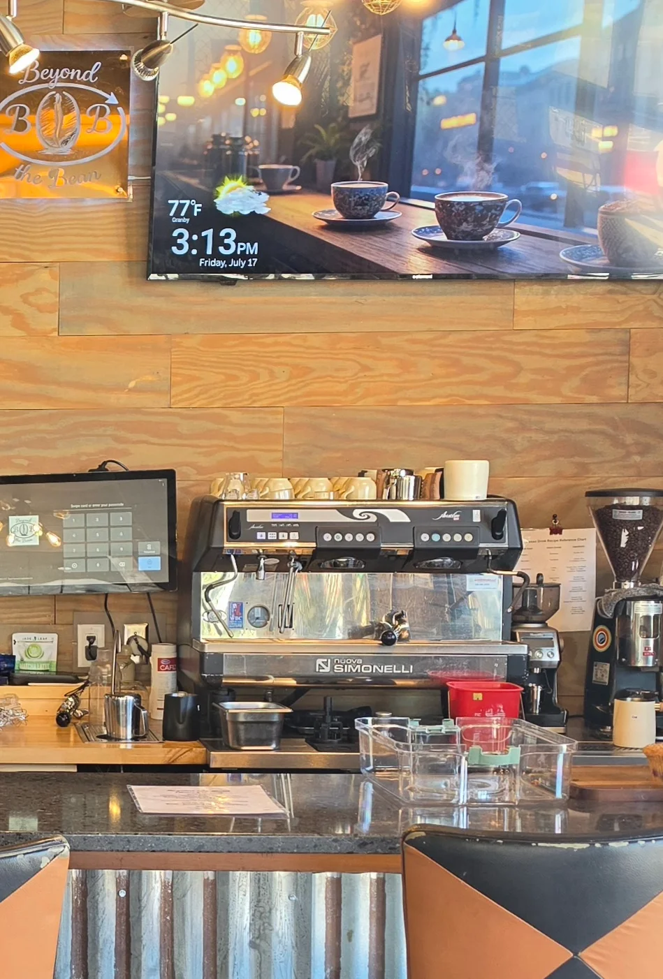 A variety of beverages including an iced coffee, a milkshake topped with whipped cream, and a cup of ice cream on a countertop.