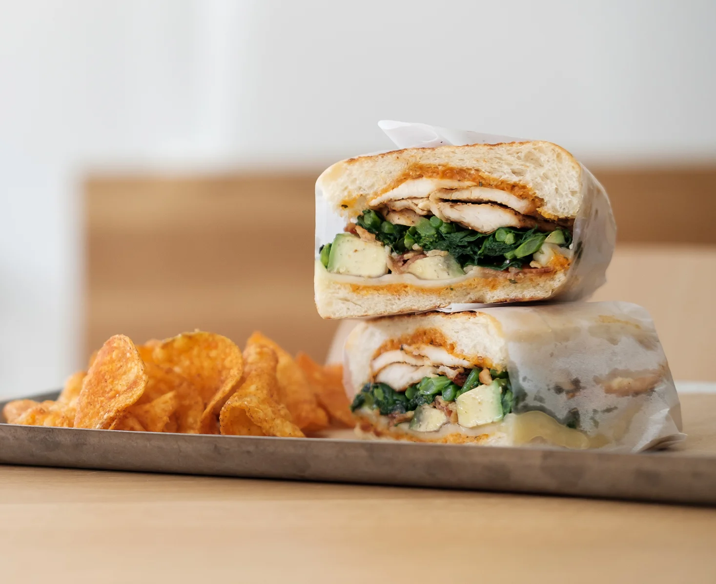 Grilled chicken sandwich with greens and chips