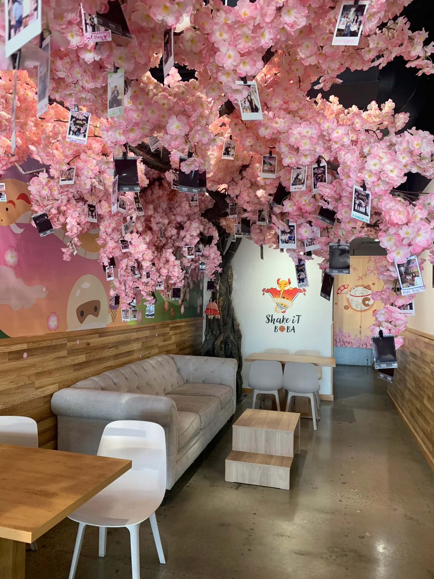 The pink blossom tree and customer photo wall inside ShakeiT Boba