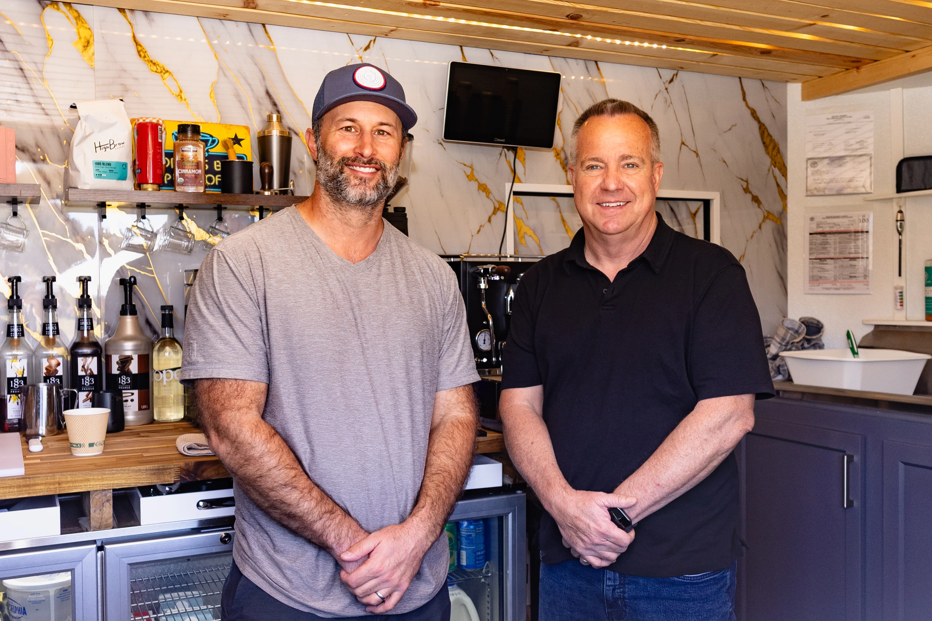 Two men standing in a modern coffee shop interior