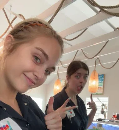Two restaurant staff members posing in a cozy dining area