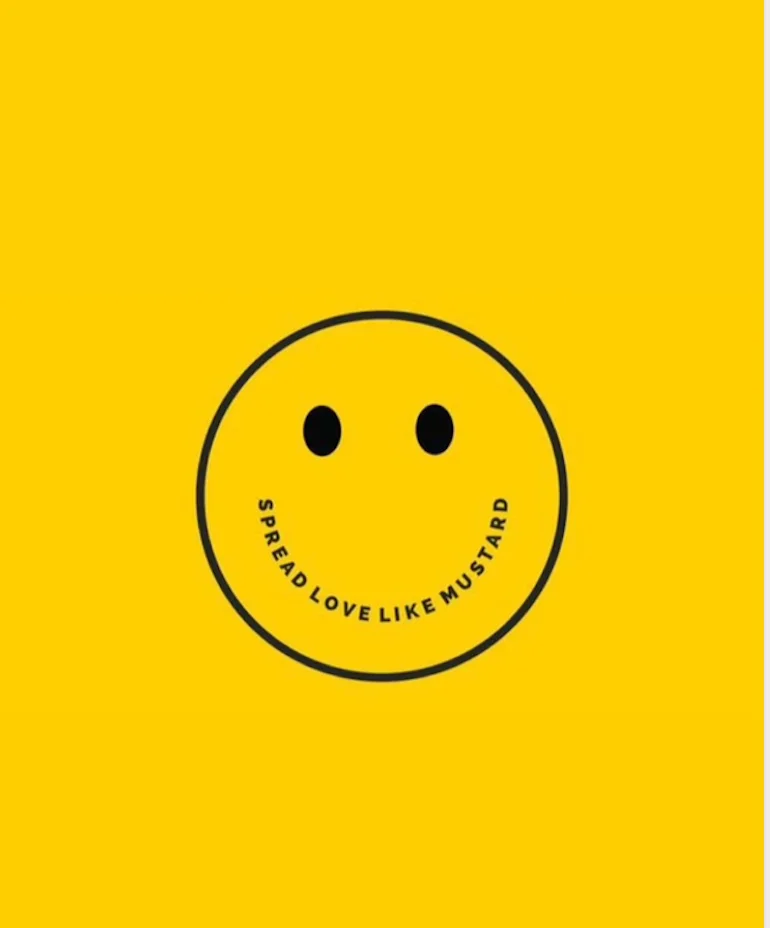 A cheerful smiley face on a bright yellow background with the text 'Spread love like mustard' wrapped around it.