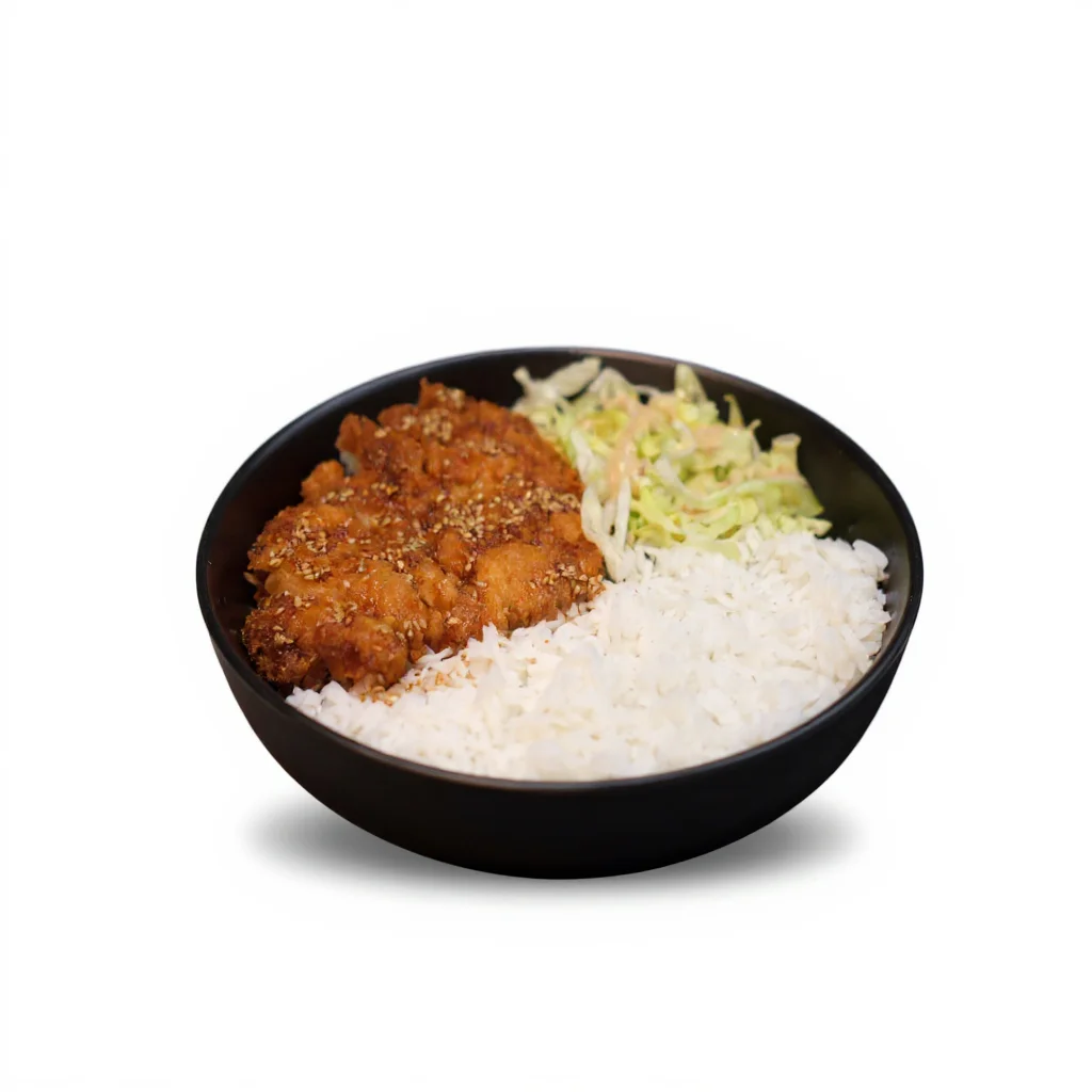 A delicious serving of fried chicken accompanied by steamed rice and a side of shredded lettuce.