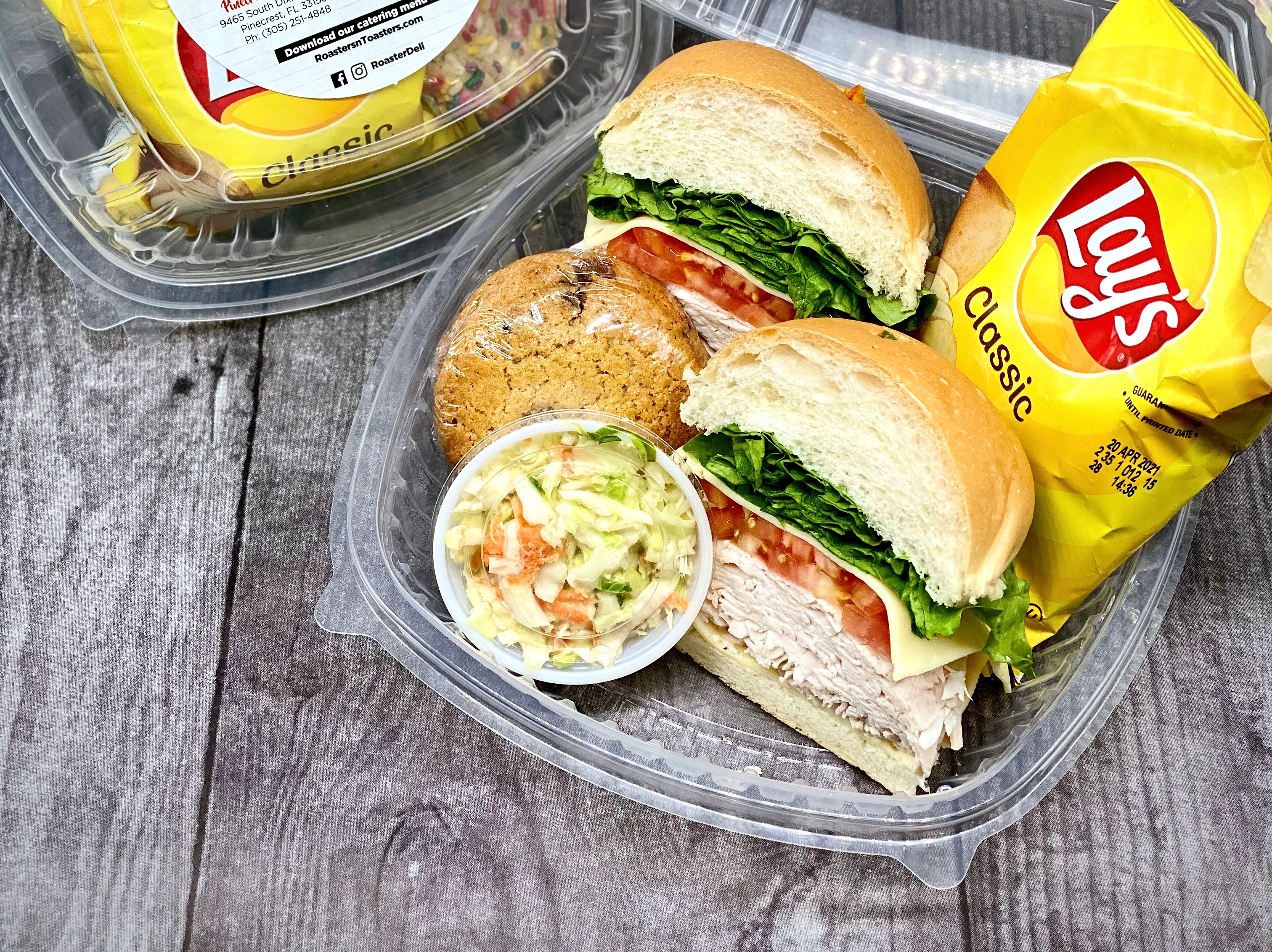 Box lunch with deli sandwich, chips, coleslaw, and cookie