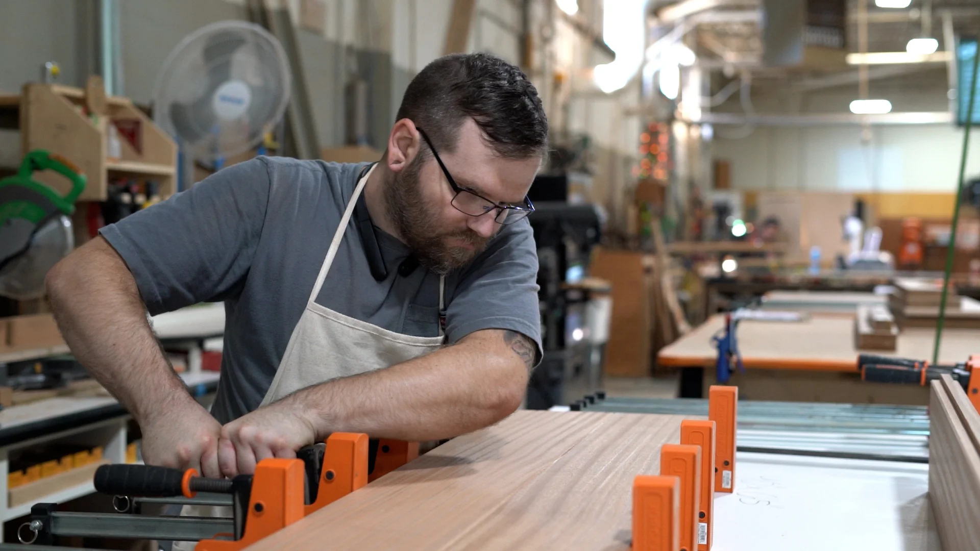 Craftsman working on wood project in a workshop with tools and materials