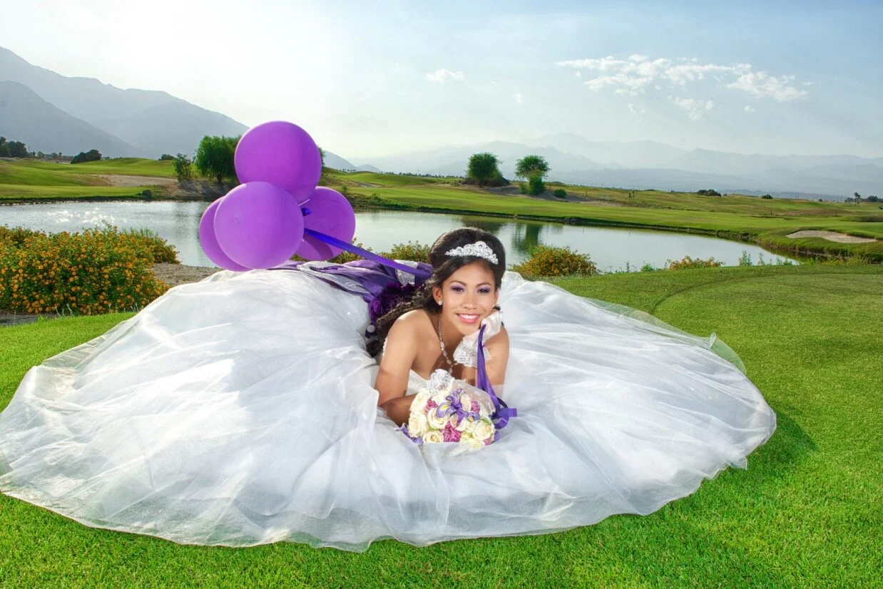 Bride in a stunning gown with purple balloons by a serene lake