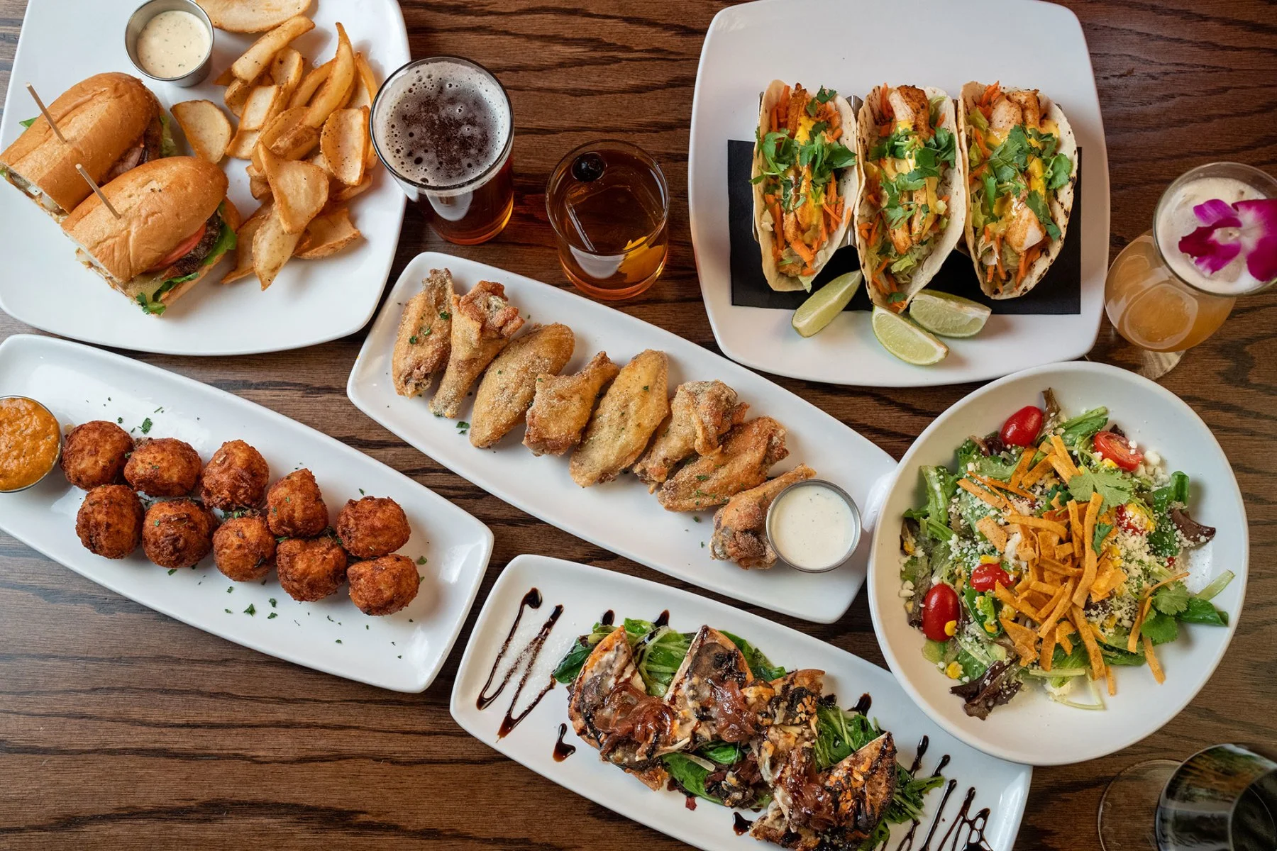 Assorted American pub food including tacos, wings, and sandwiches