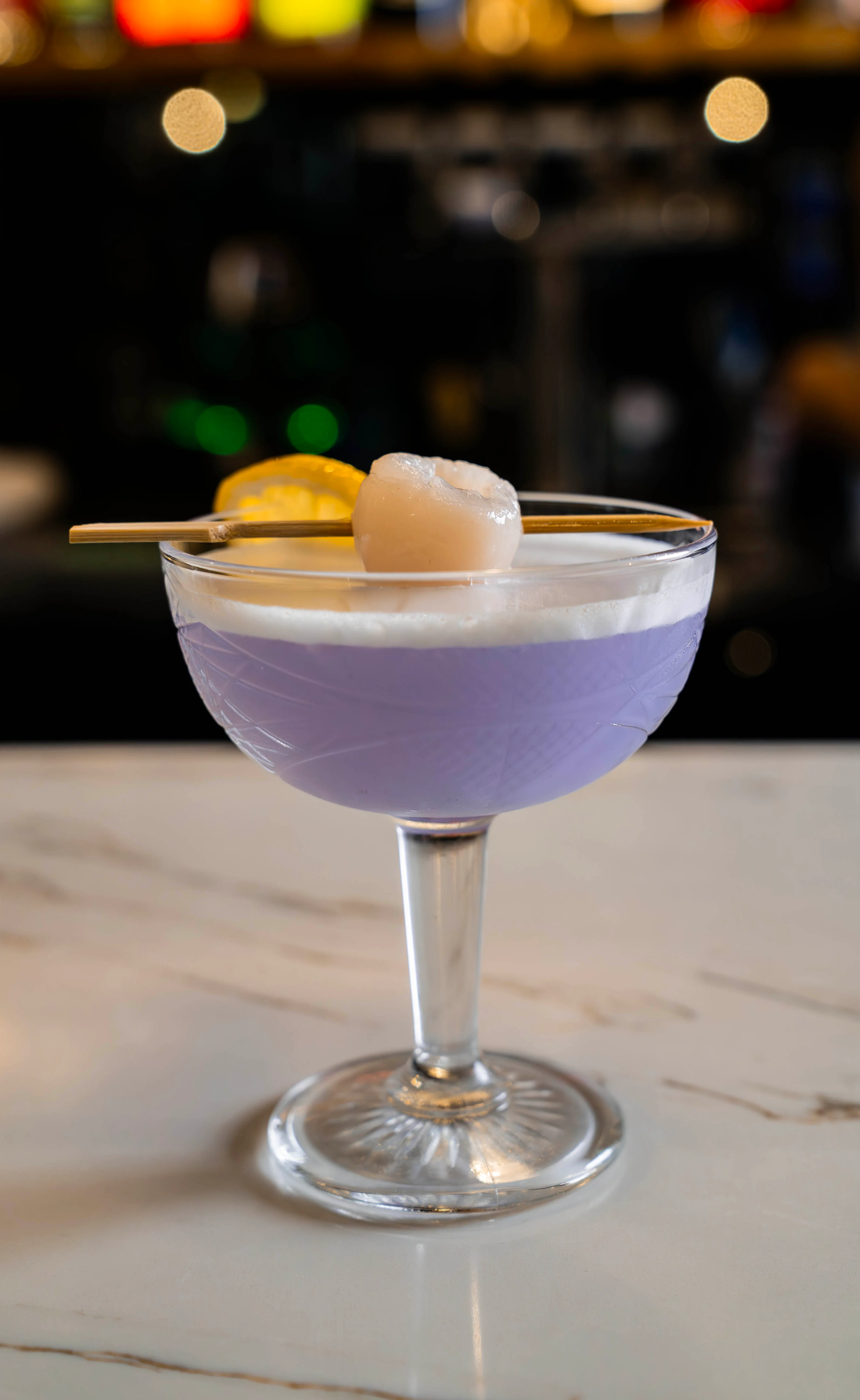 A vibrant Lychee Dream cocktail garnished with fresh fruit.