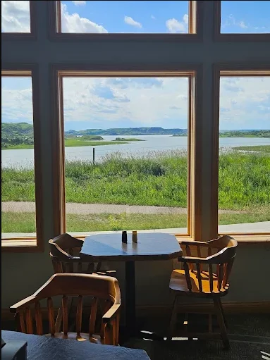 Scenic restaurant view overlooking a tranquil lake and green hills