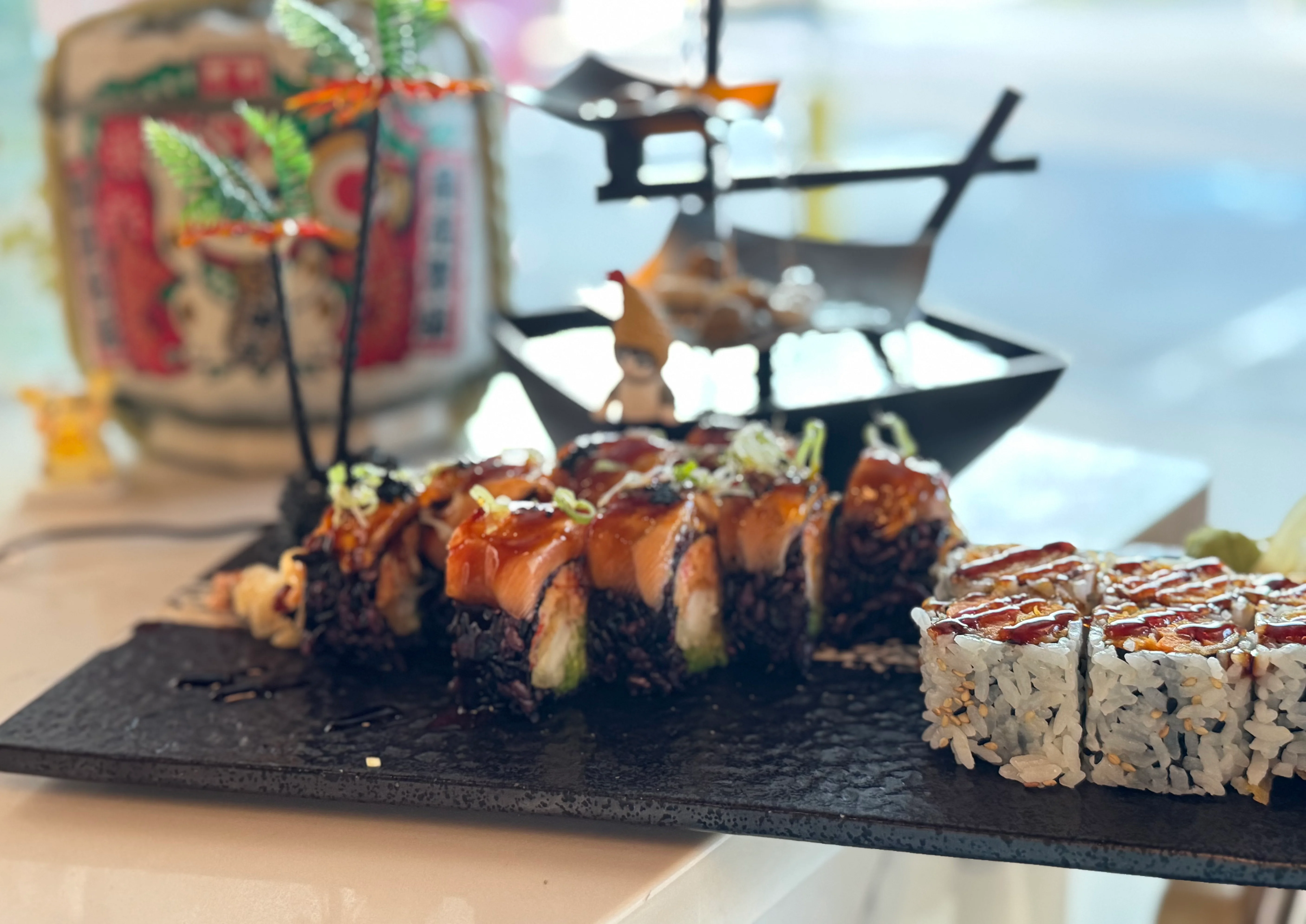 Artfully arranged sushi platter with black rice and eel sauce
