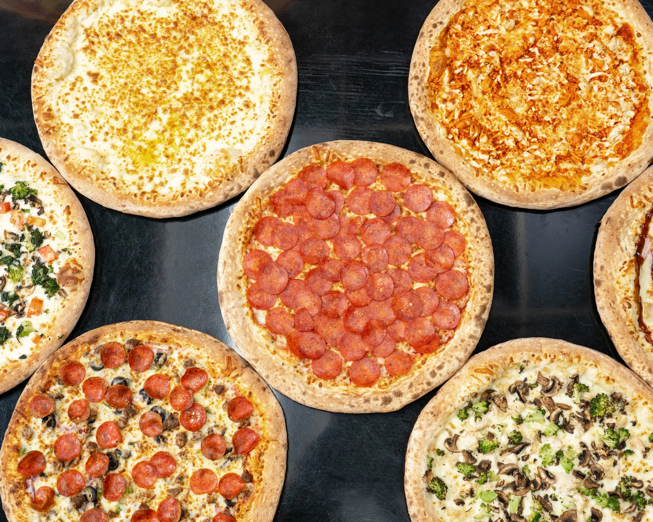 Variety of gourmet pizzas including pepperoni and vegetarian options