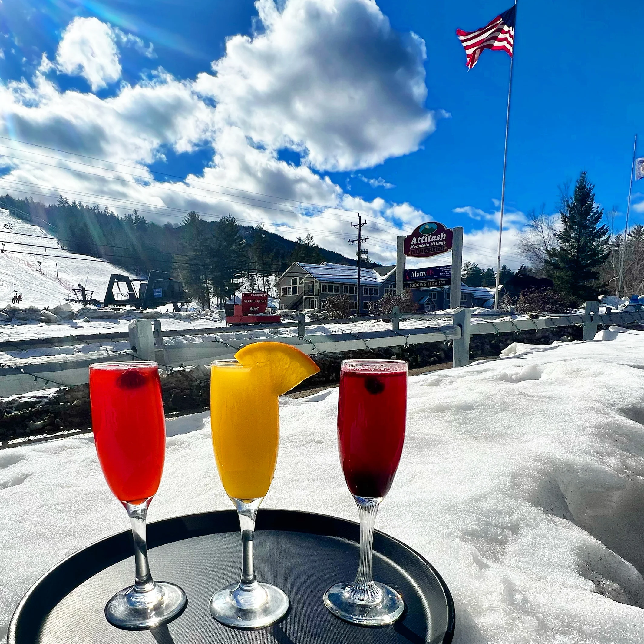 Colorful cocktails on a tray with snowy mountain backdrop