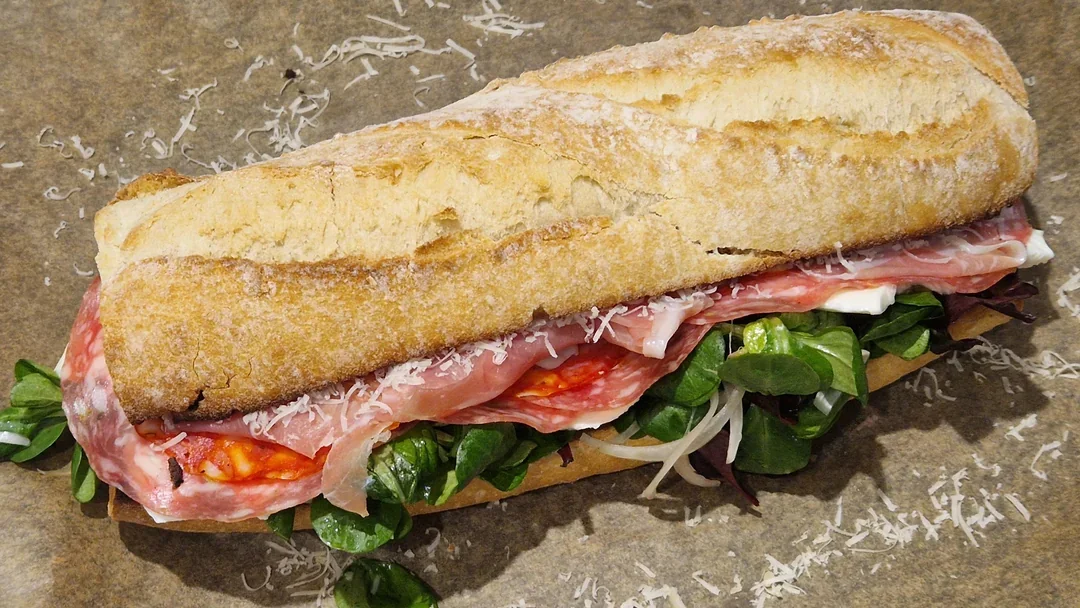 A platter featuring serrano ham, fennel salami, spicy salami, and fresh mozzarella.