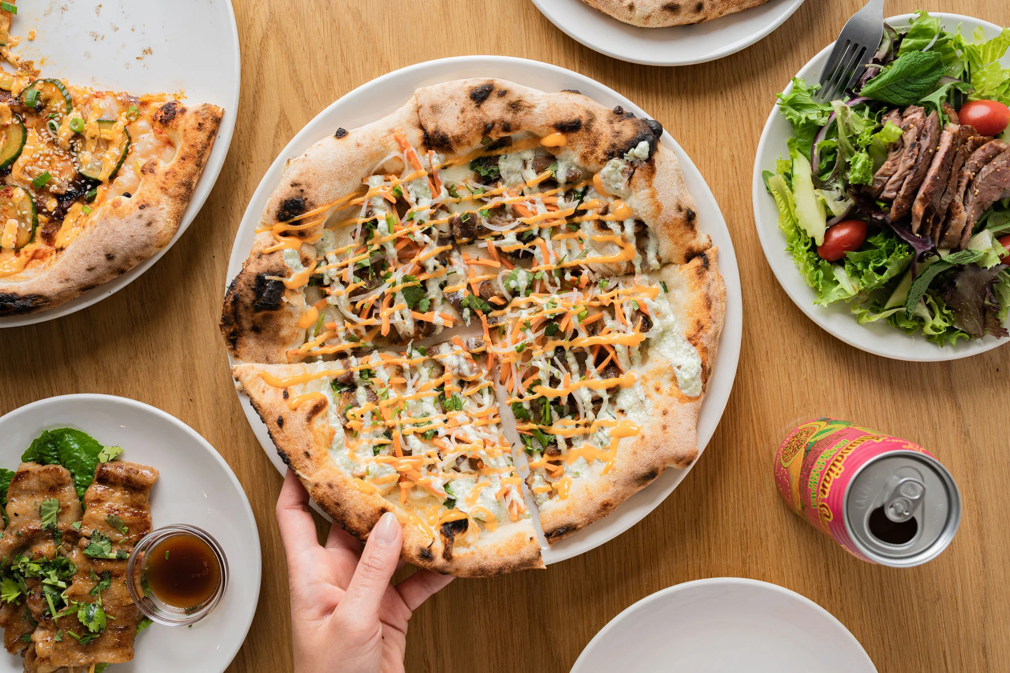 Fusion pizza topped with fresh herbs and drizzled sauce
