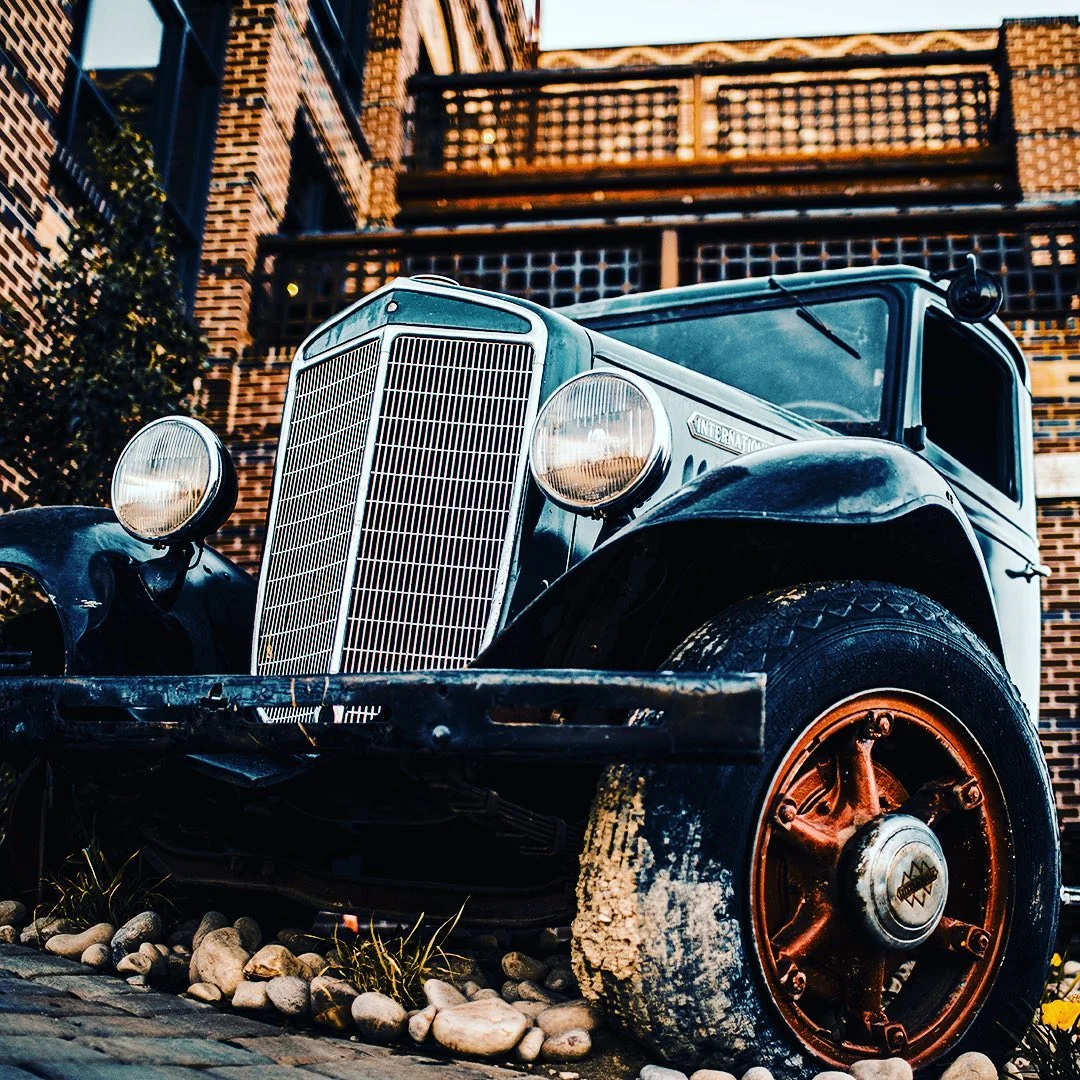 Vintage car parked outside a rustic building