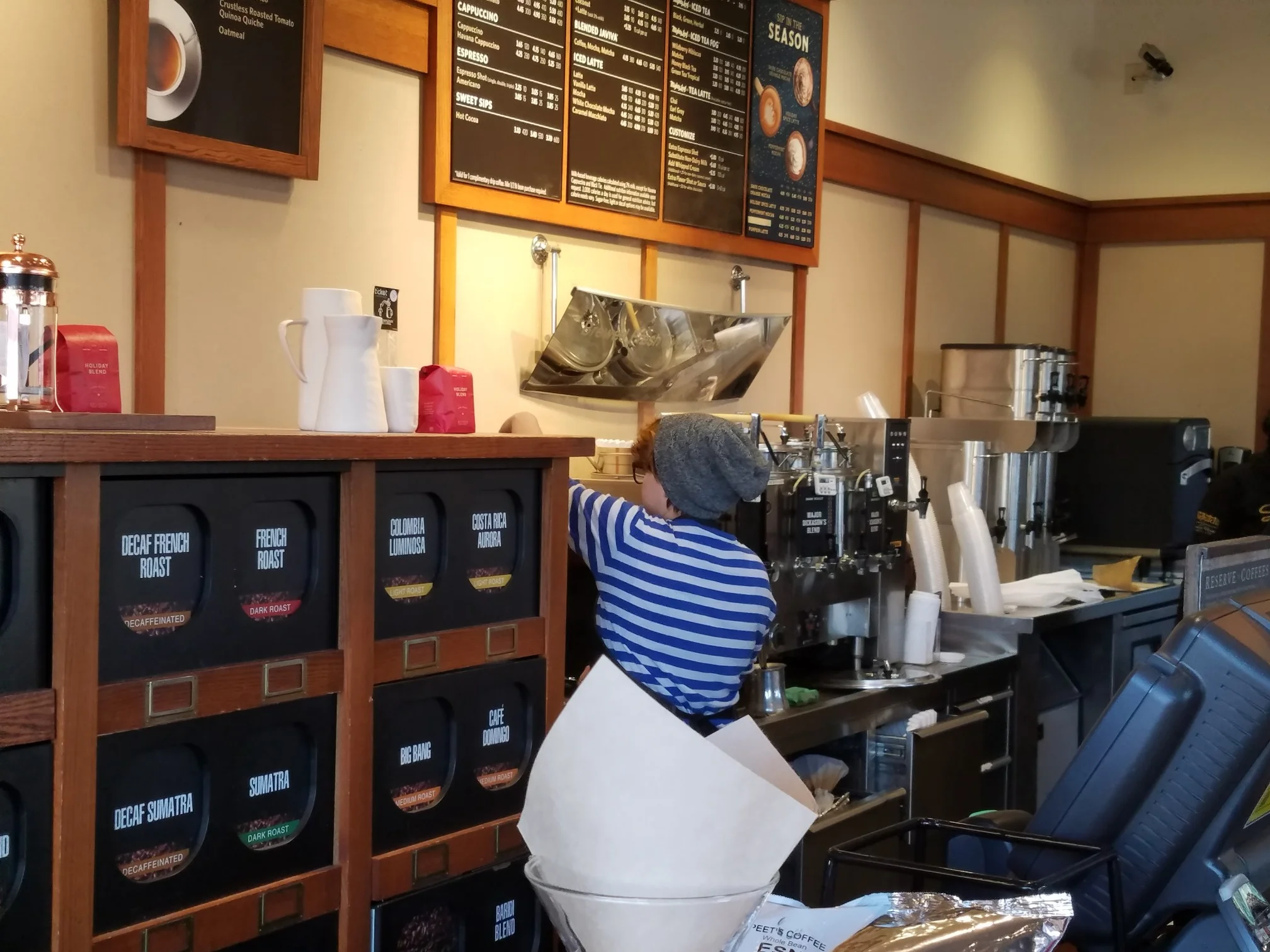Barista preparing coffee in a cozy café interior
