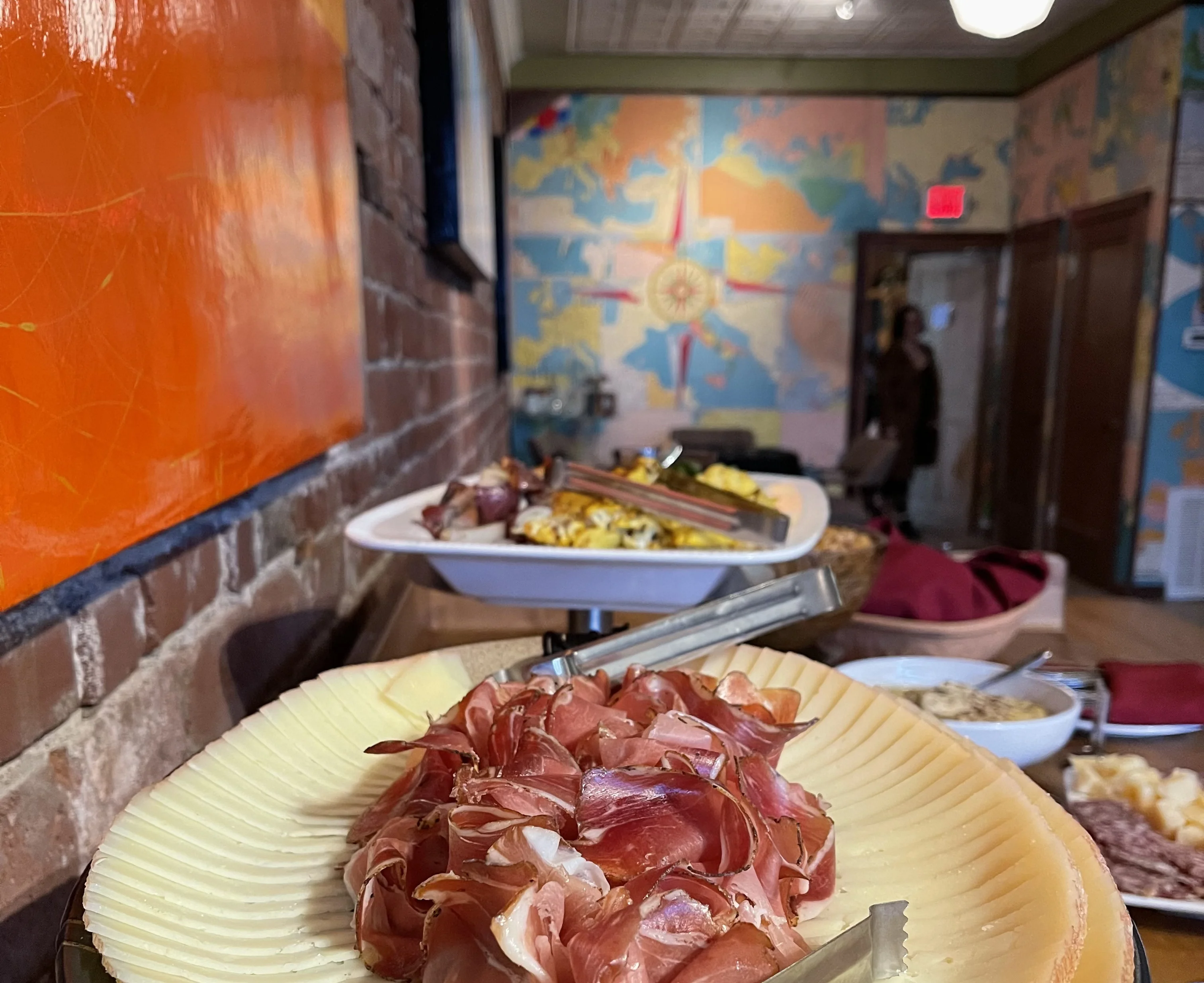 Charcuterie platter featuring cured meats in a cozy restaurant setting