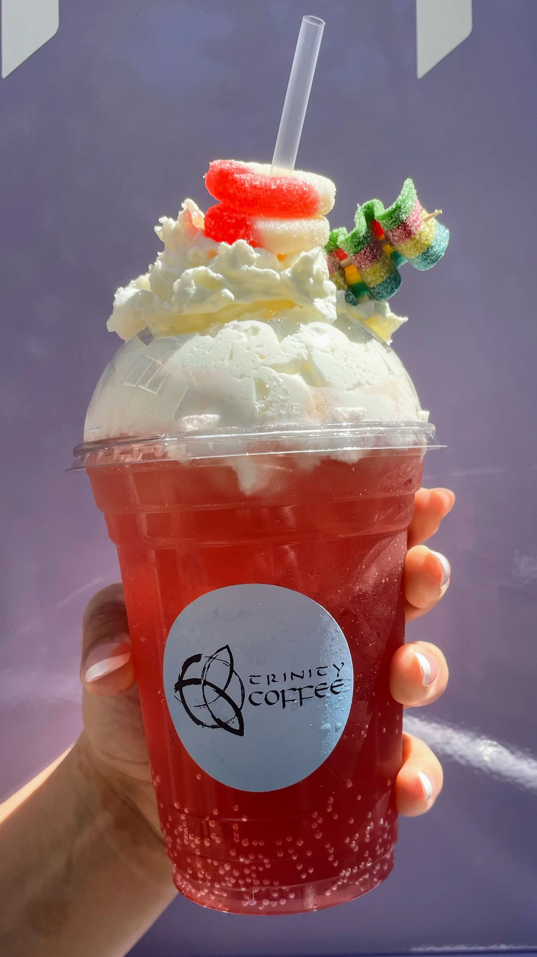 Colorful soda drink topped with whipped cream and candy