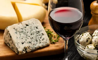 Wine and cheese platter with assorted cheeses and red wine