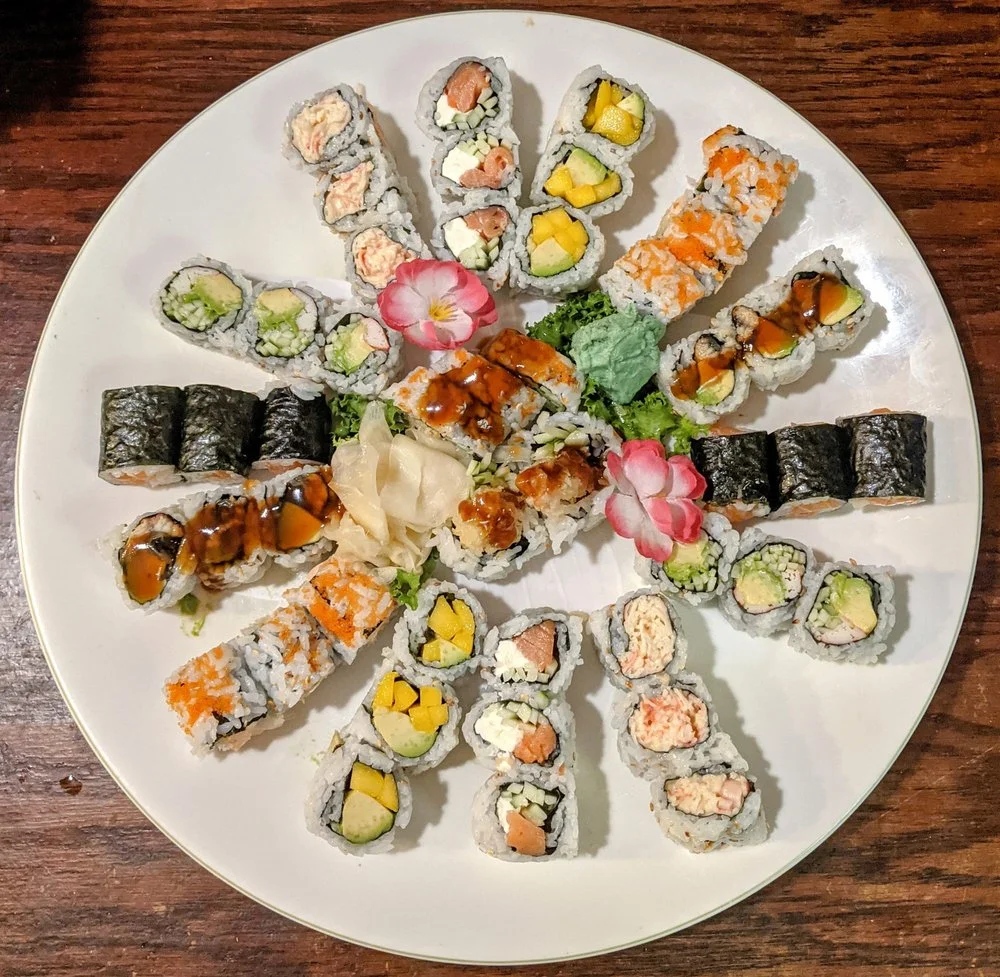 Assorted sushi platter featuring various rolls and garnishes