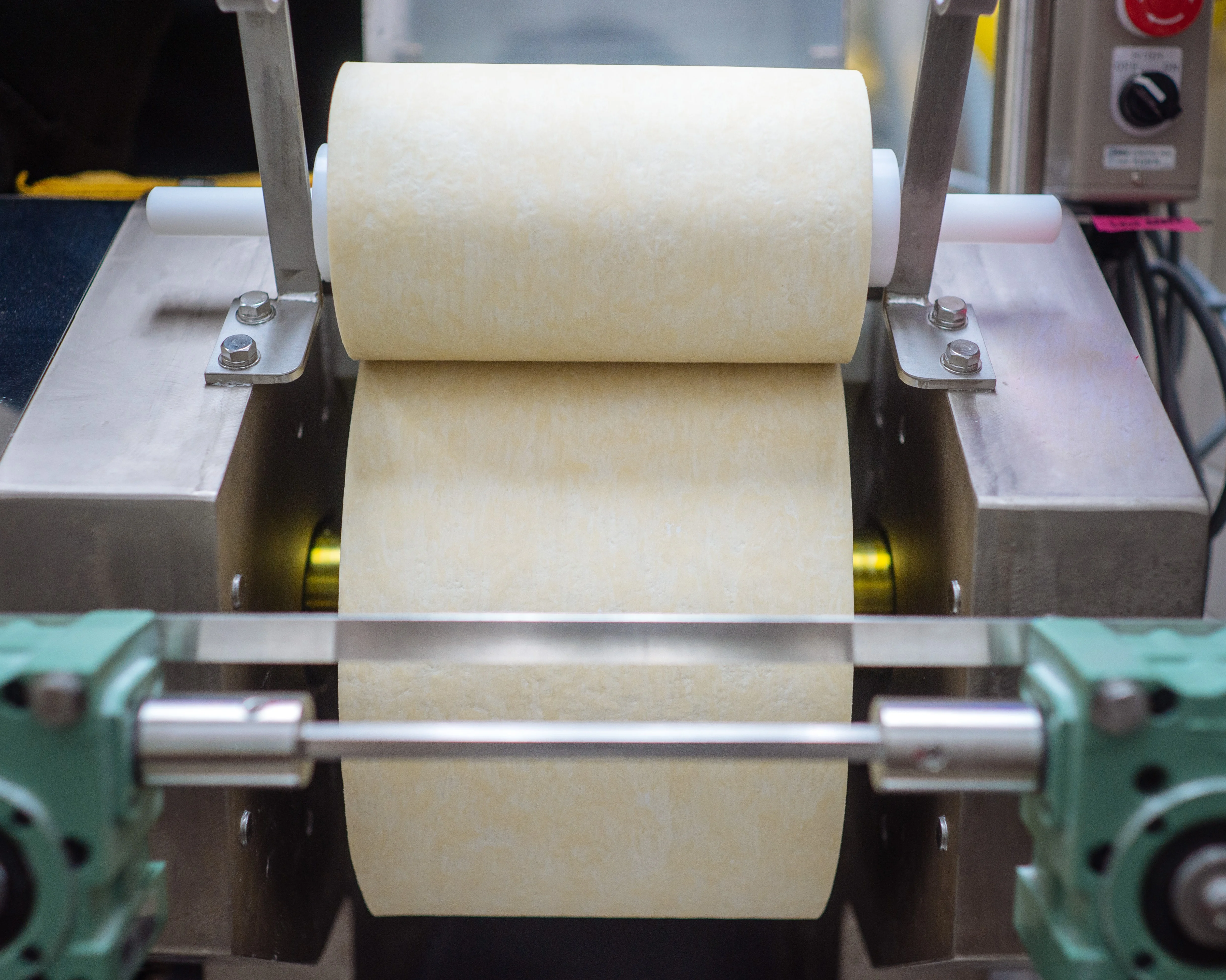 Noodle dough being rolled into a smooth sheet during preparation at Goma Tei.