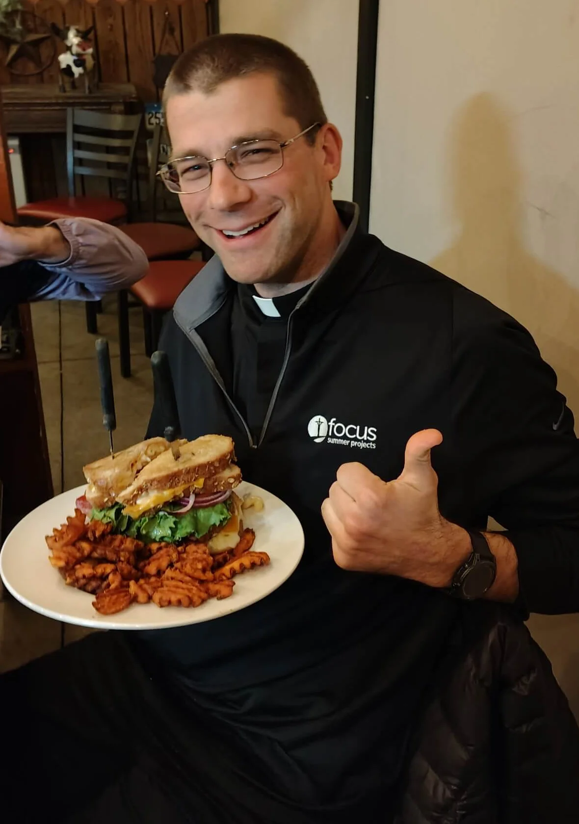 Delicious sandwich with sweet potato fries in a cozy restaurant setting