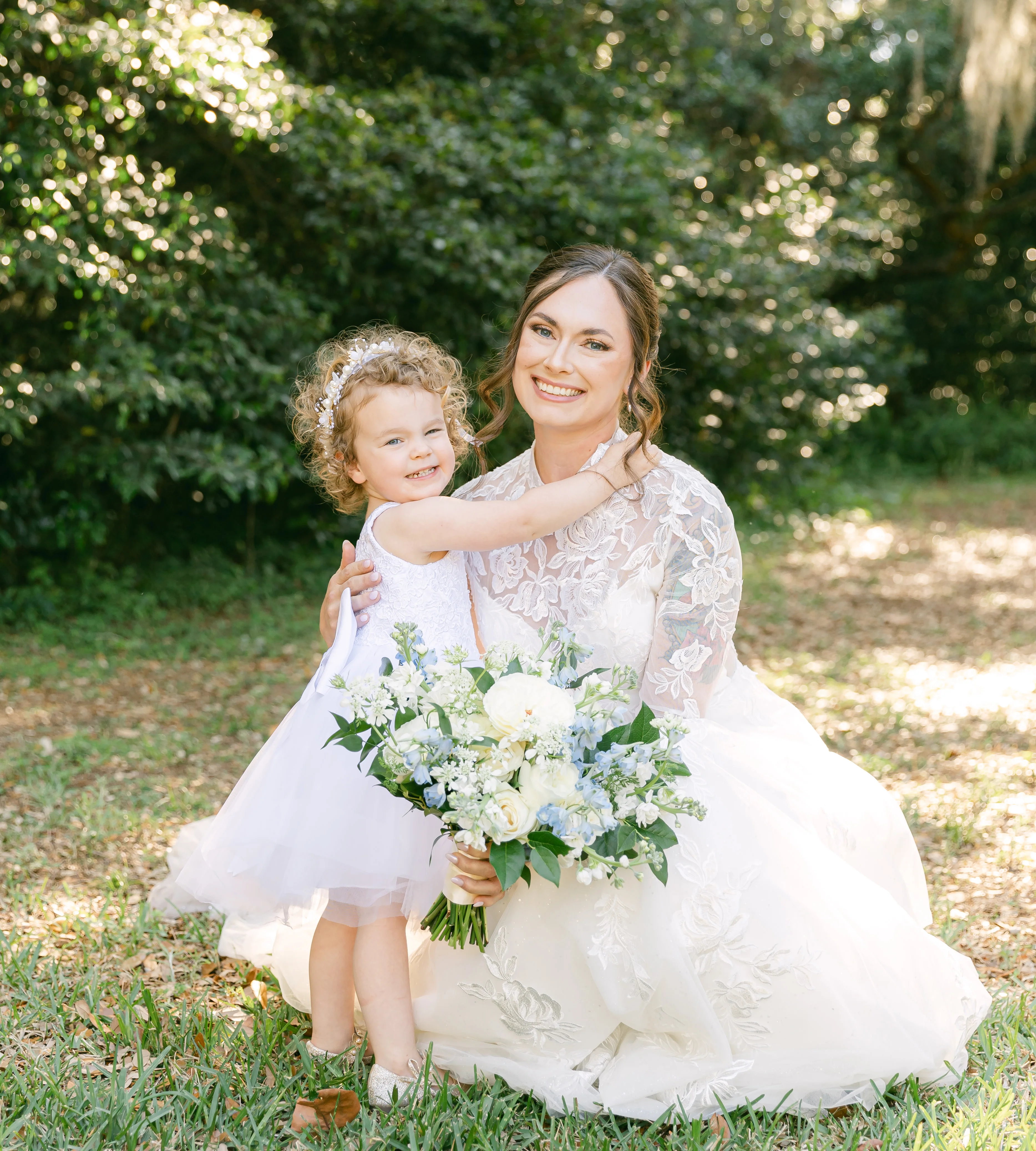 Bride and flower girl in a sunny garden setting