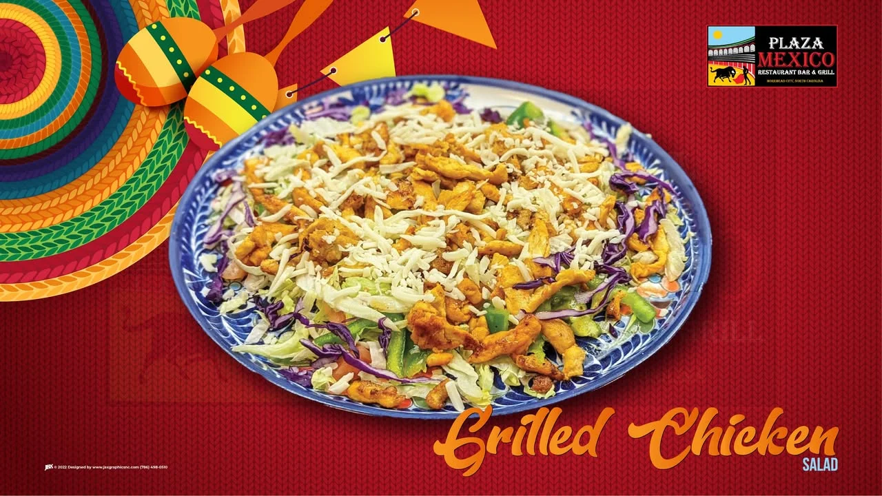 A vibrant grilled chicken salad featuring shredded chicken on a bed of mixed greens and topped with cheese, served on a decorative plate.