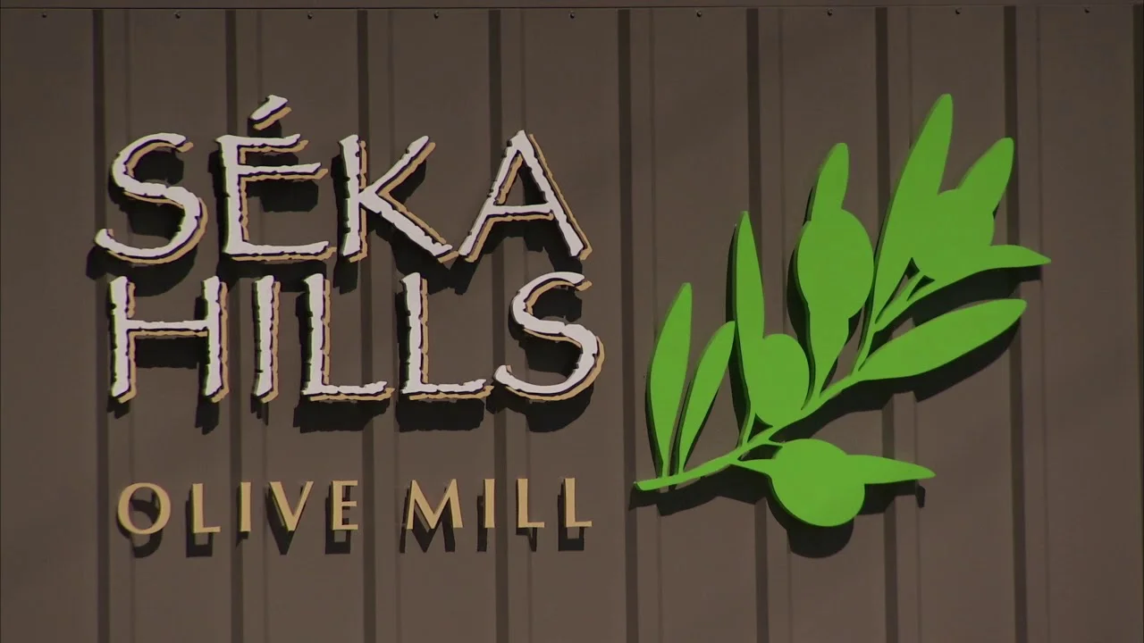 Sékahills Olive Mill sign with olive branch design