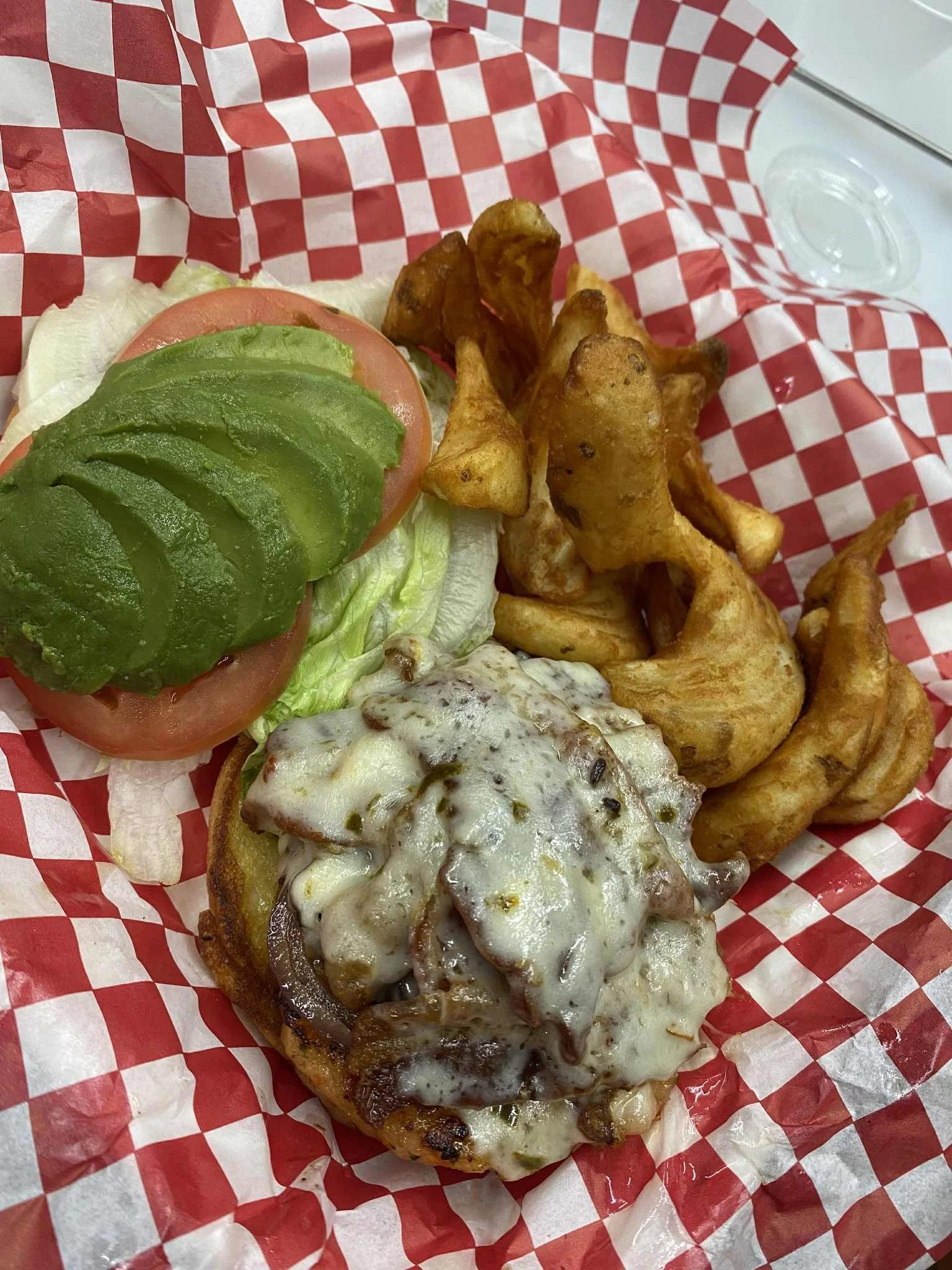 Juicy cheeseburger with avocado and crispy potato wedges