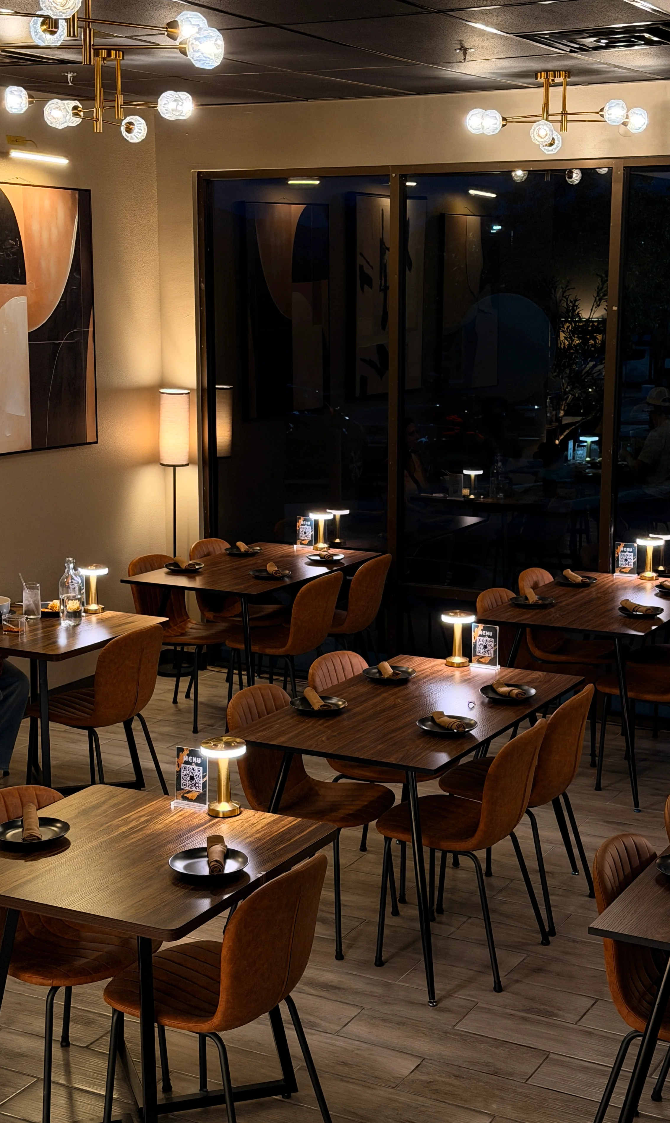Elegant restaurant dining room with warm lighting and modern chandeliers
