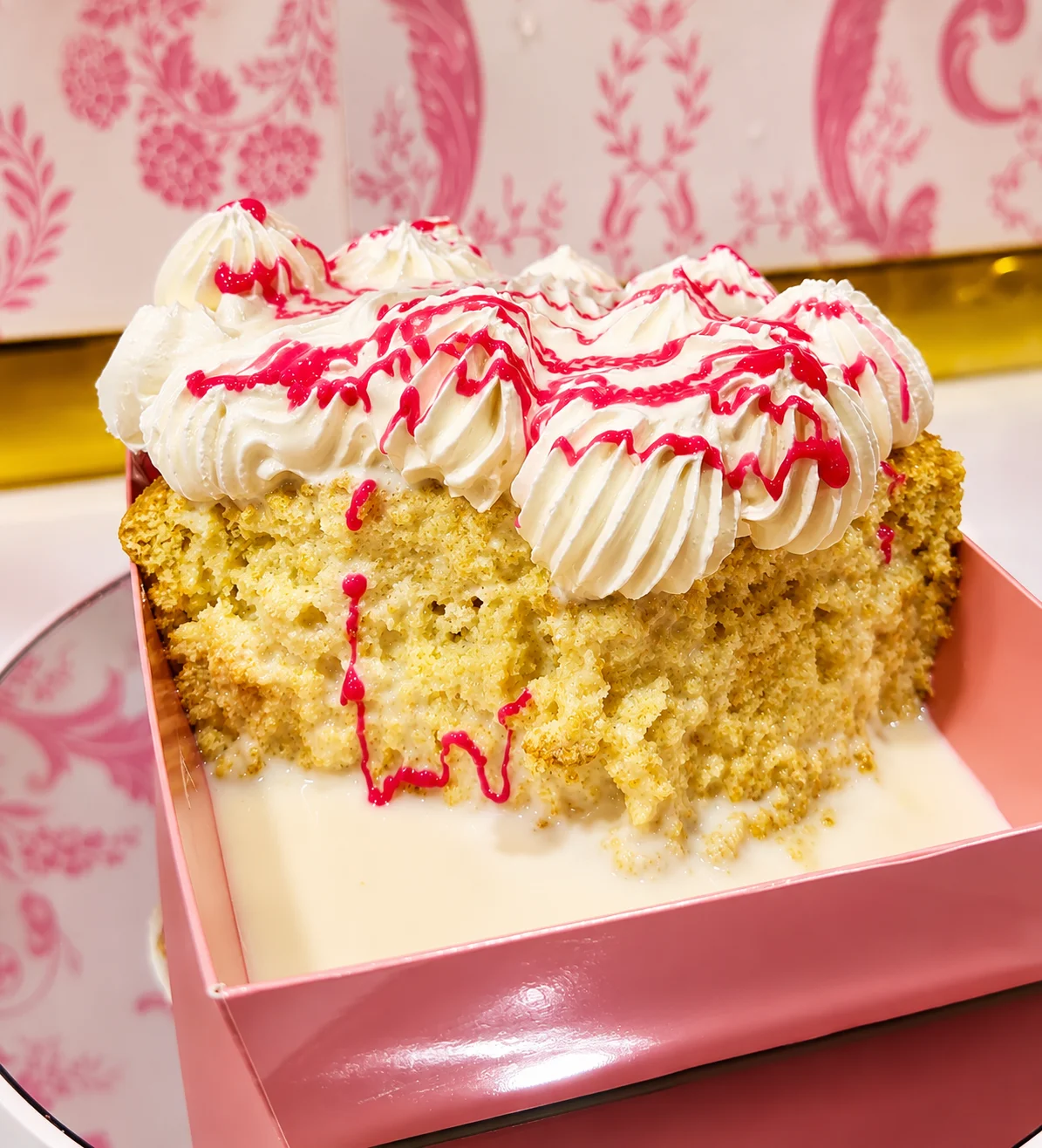 Delicious slice of vanilla cake with cream and raspberry drizzle