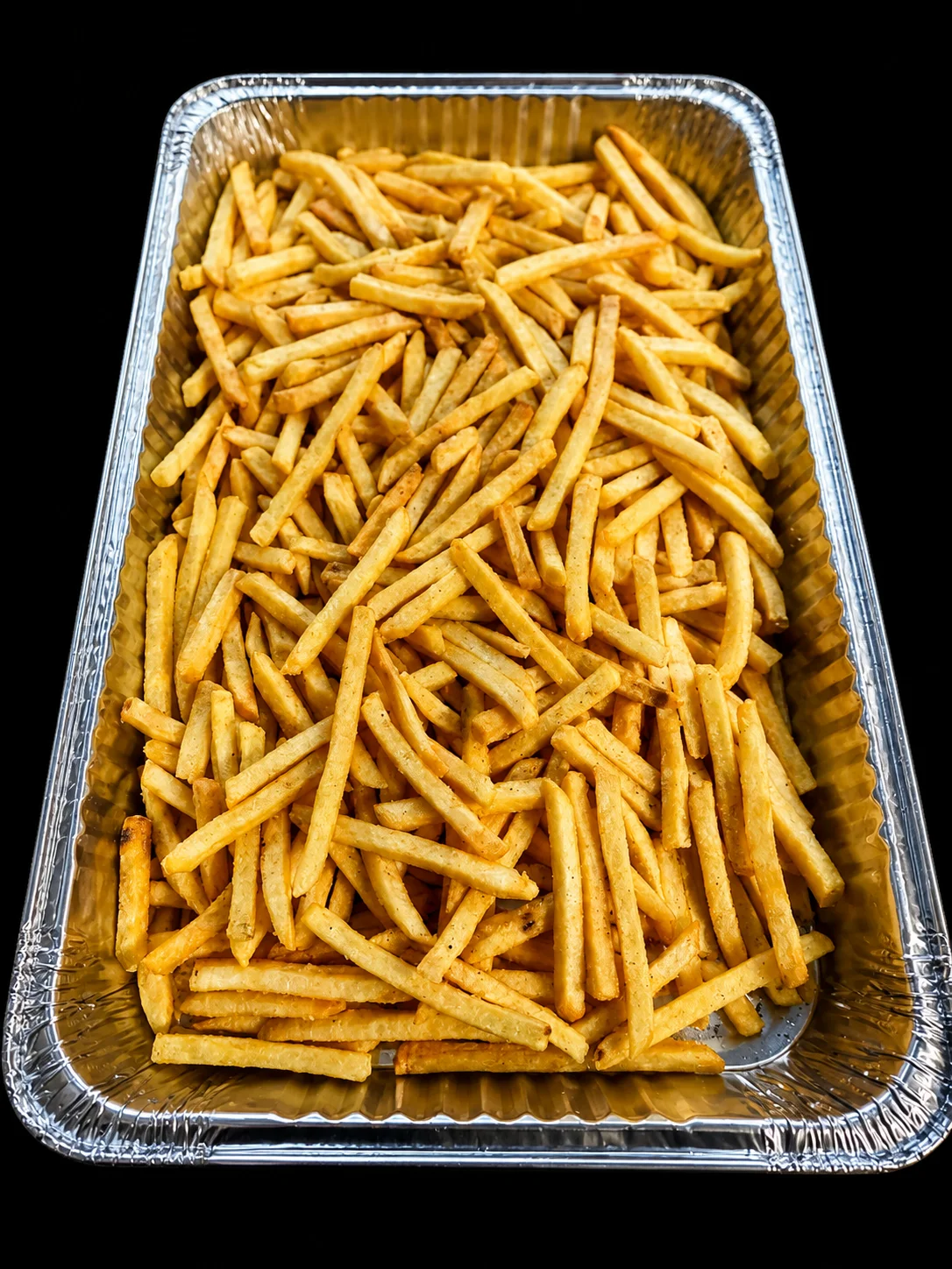 Crispy French fries in a catering tray