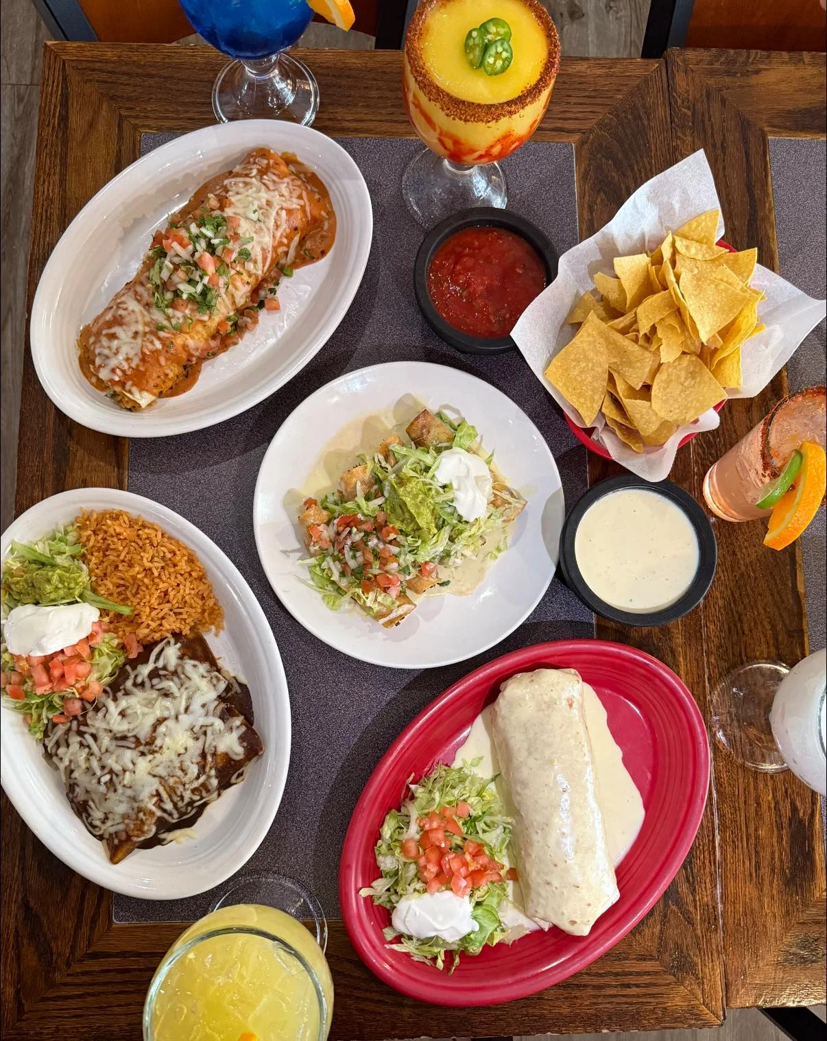 Colorful Mexican feast with enchiladas, tacos, and drinks