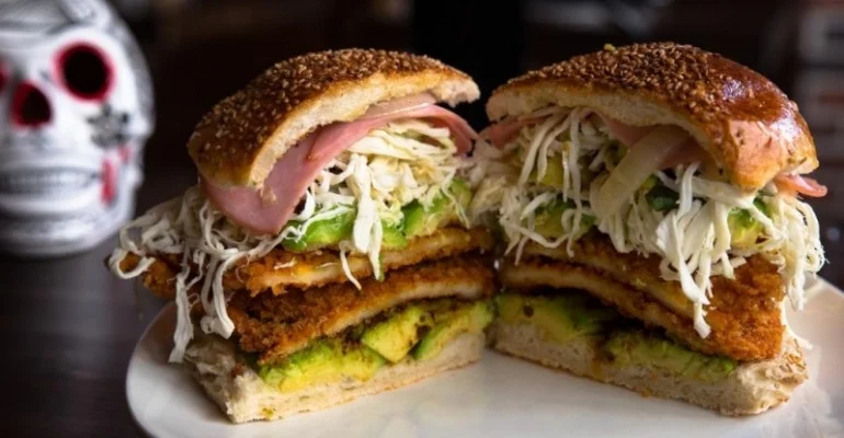 Mexican torta ahogada with crispy layers and fresh toppings
