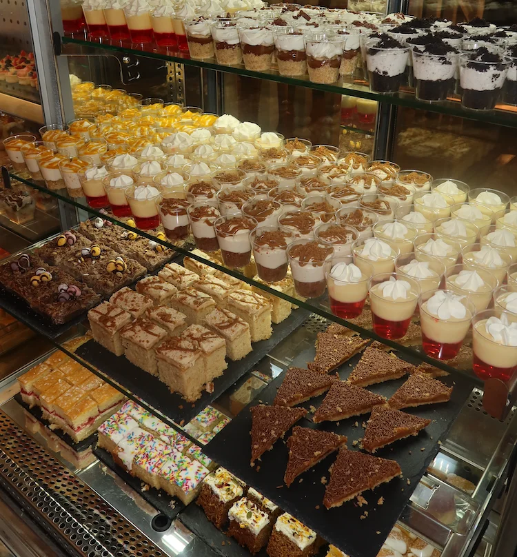 Display of assorted desserts and pastries in a glass case.