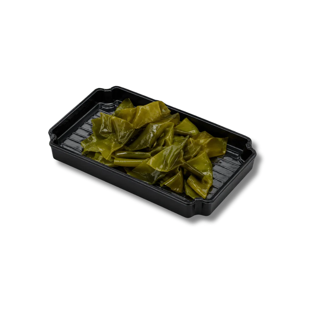 A black container filled with green seaweed pieces.