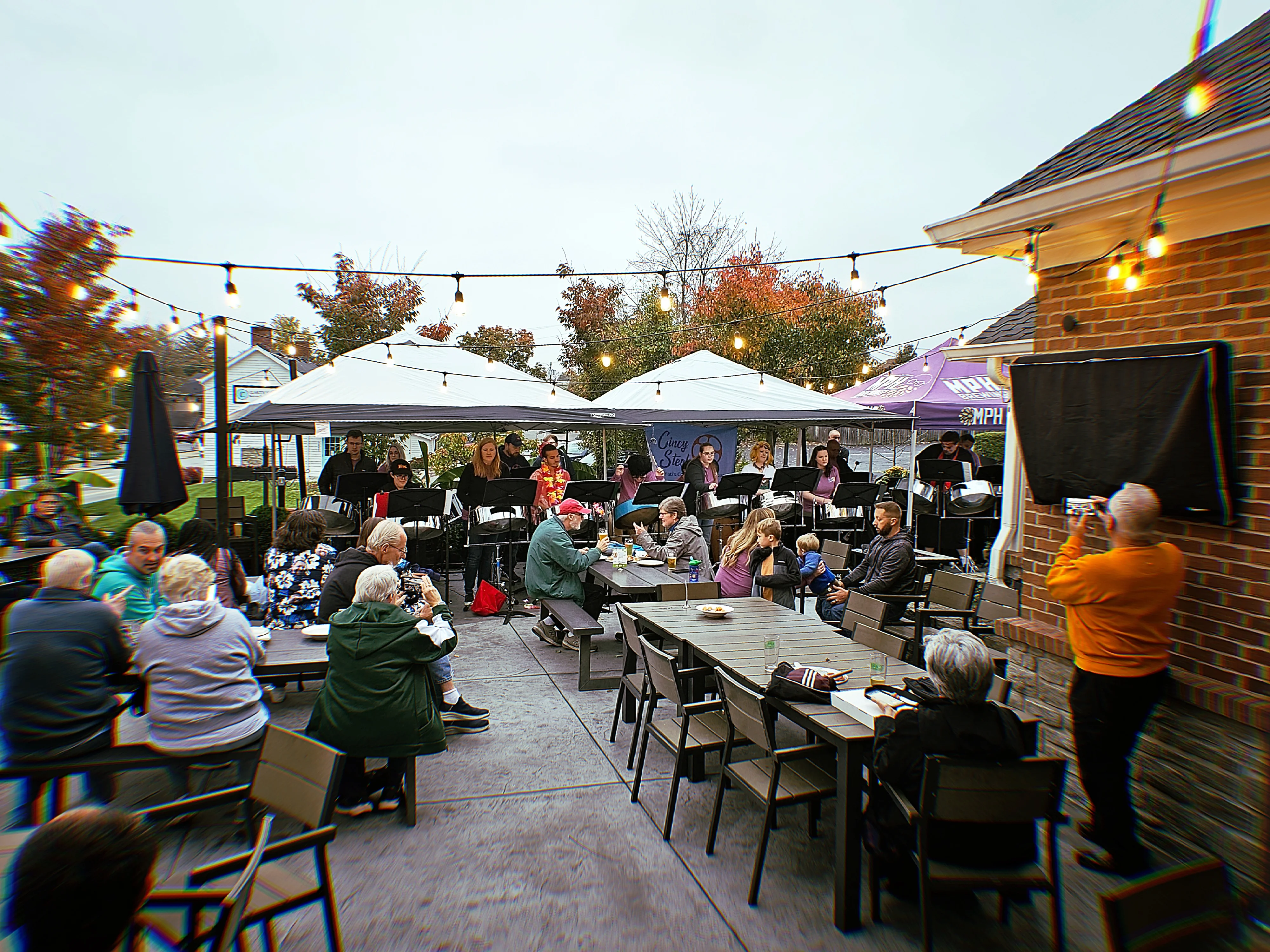A vibrant fall concert scene with people enjoying live music outdoors.