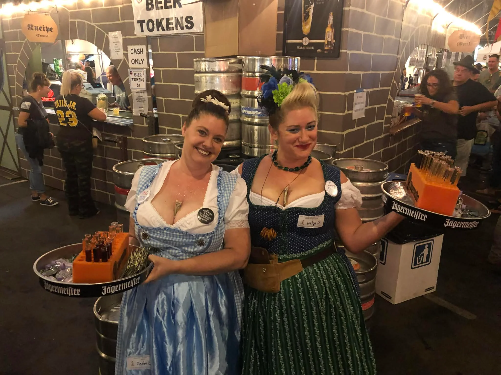 Two servers in traditional attire at a festive beer event