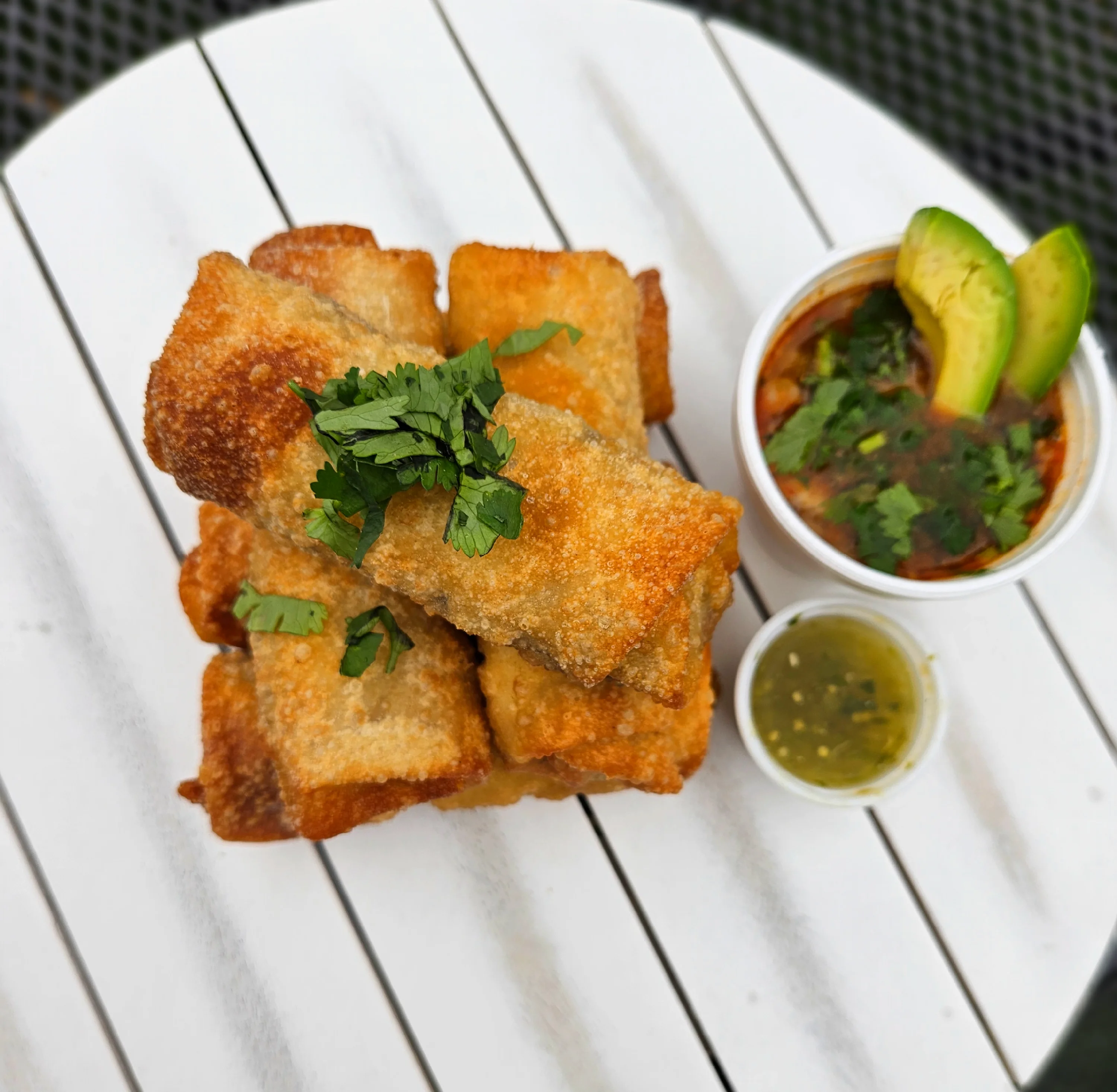 Crispy Mexican flautas served with salsa and avocado