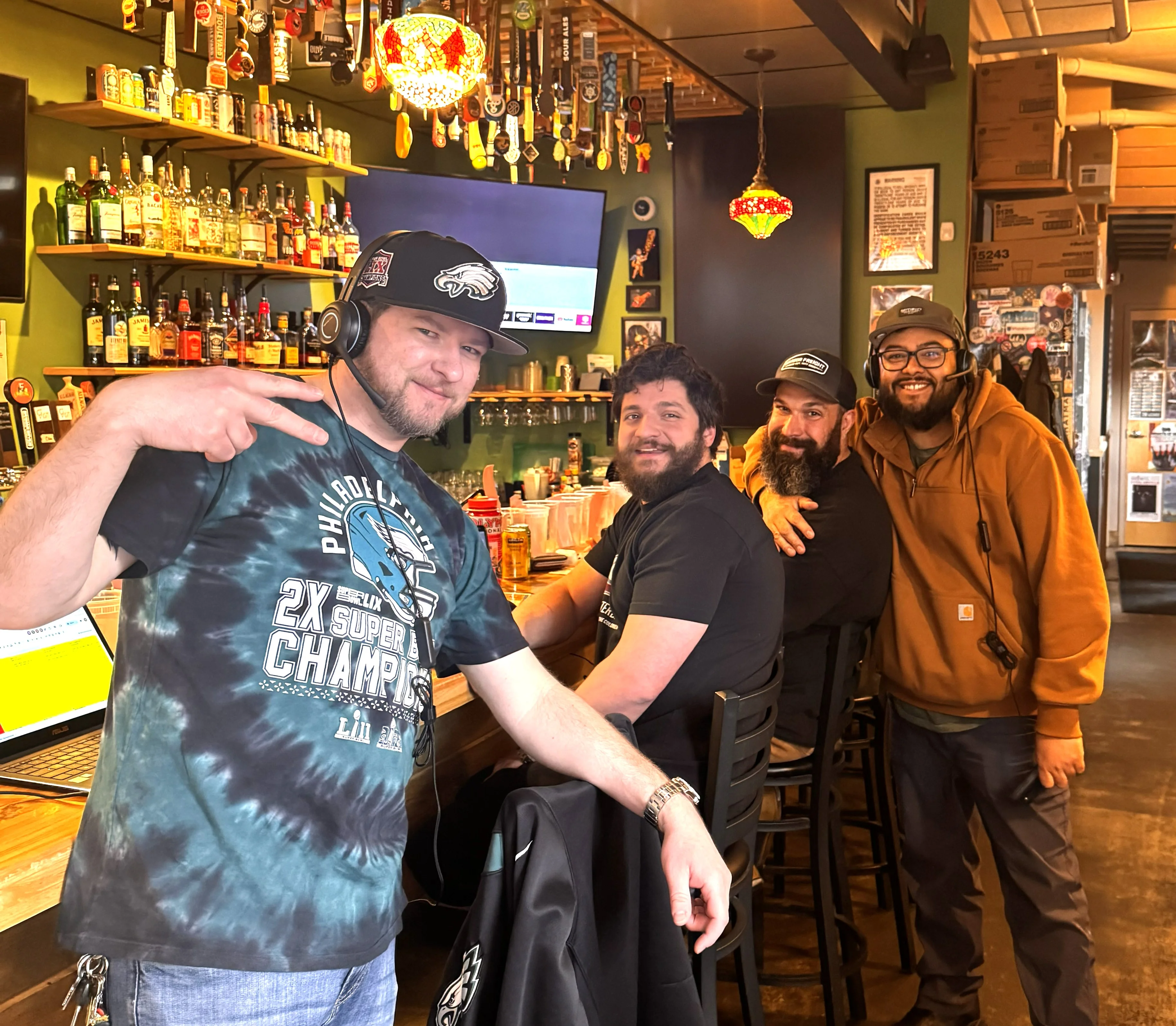Bartenders smiling at a lively bar with colorful decor