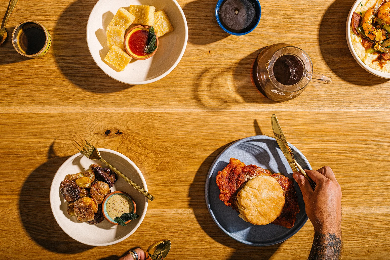 Southern fried chicken with biscuit and sides on a wooden table