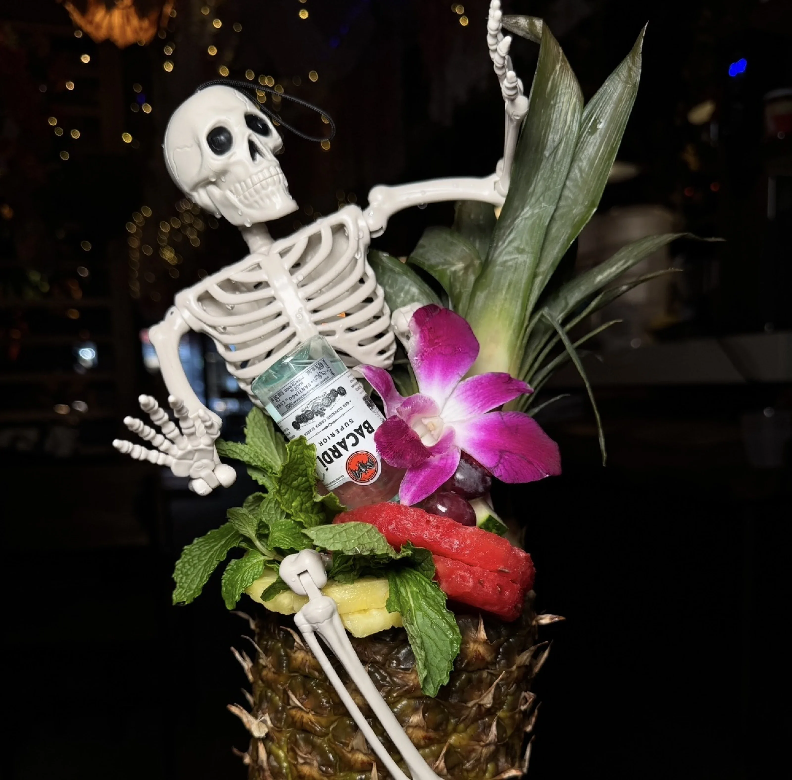 Creative cocktail served in a pineapple with a skeleton decoration