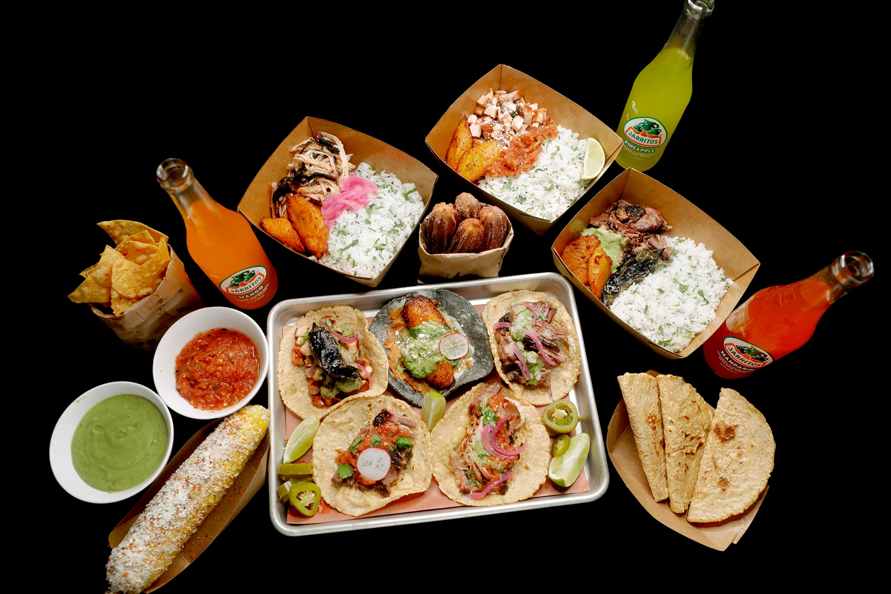 Colorful Mexican taco platter with rice and drinks