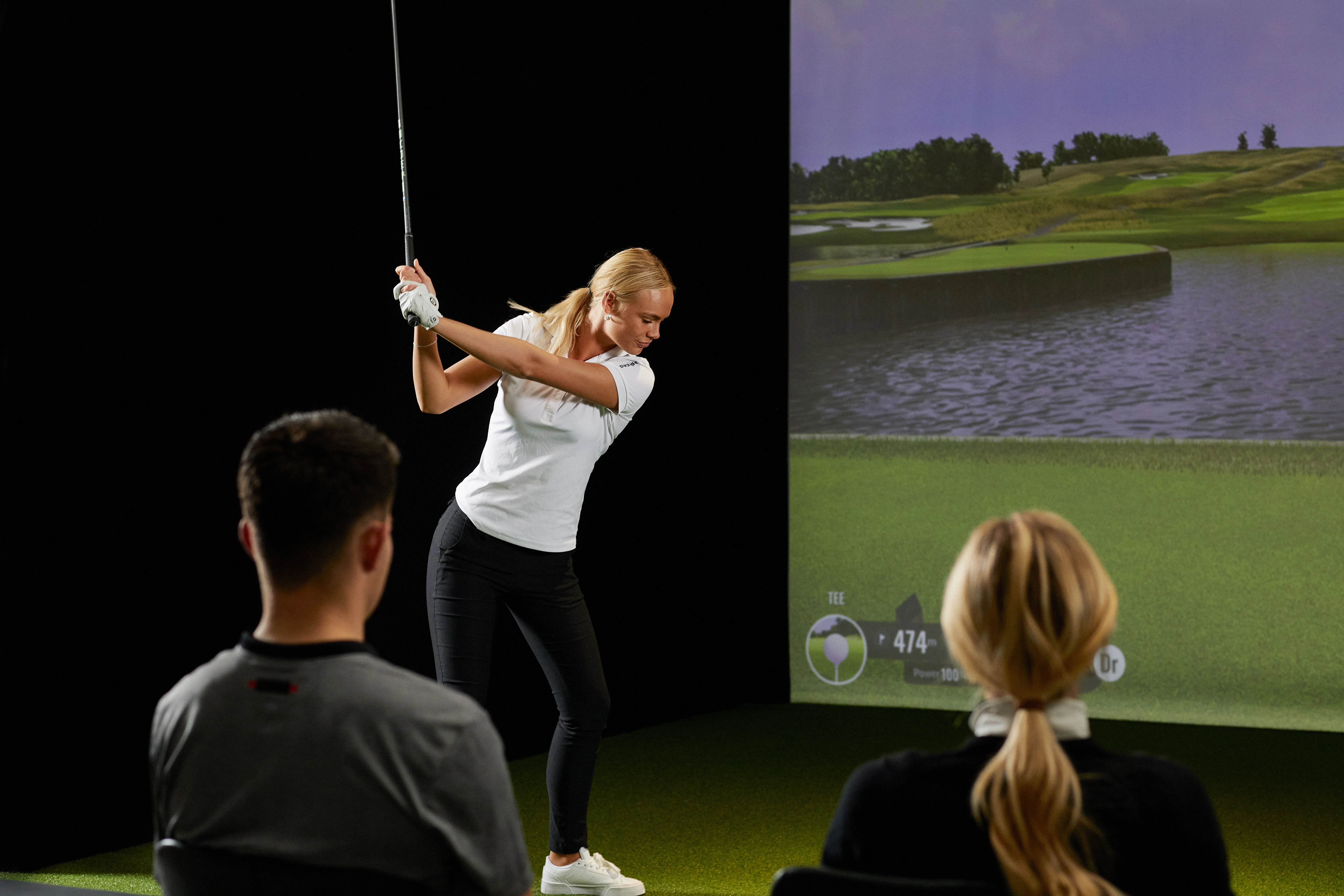 Golfer practicing swing in a virtual simulator