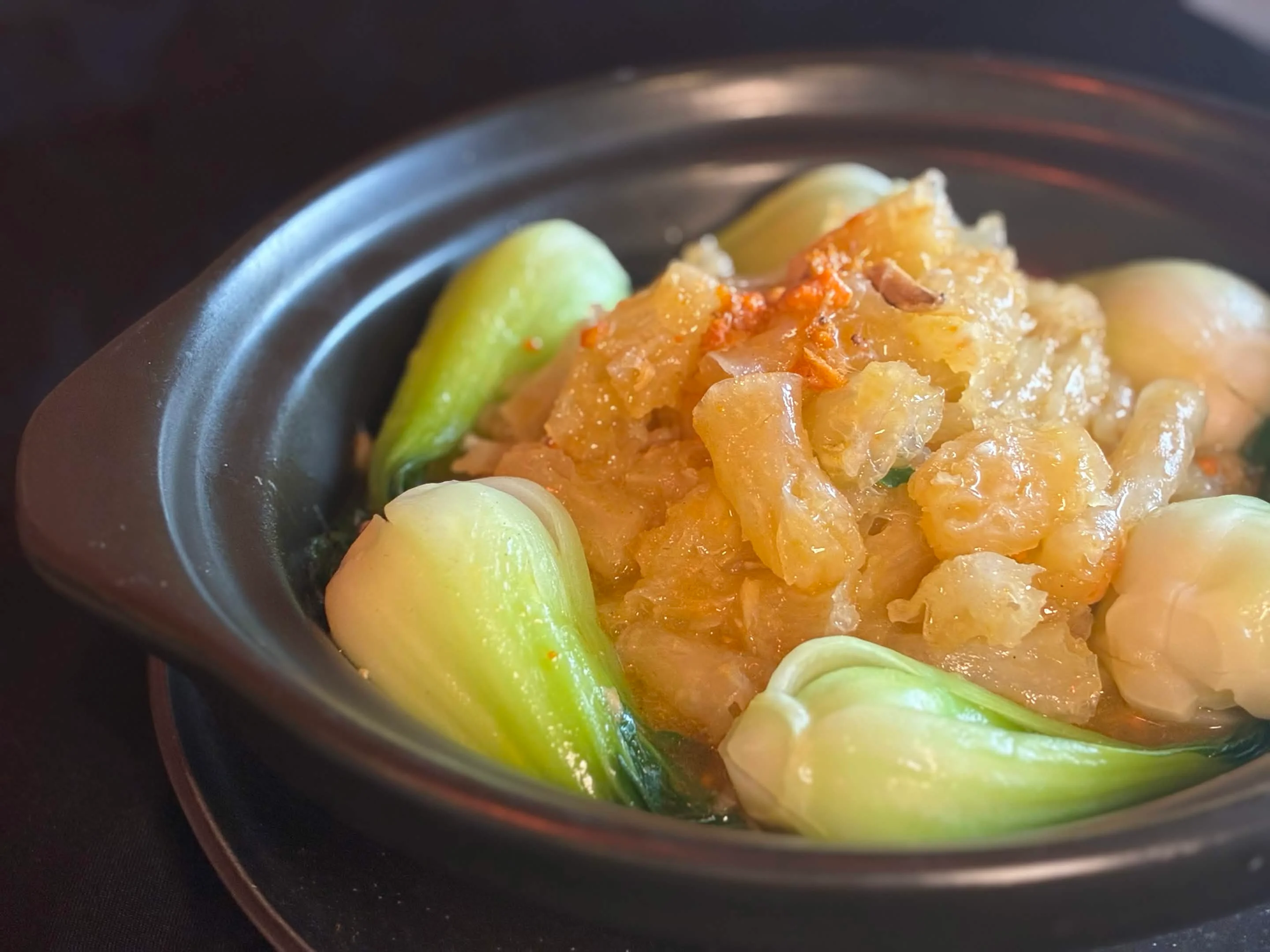 Chinese steamed fish with bok choy in clay pot