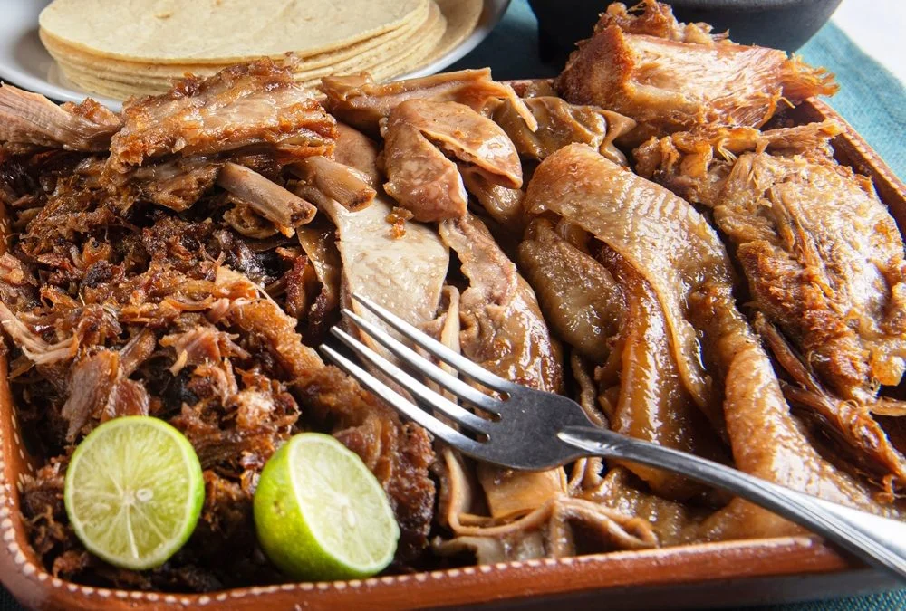 Authentic Mexican carnitas served with lime and tortillas