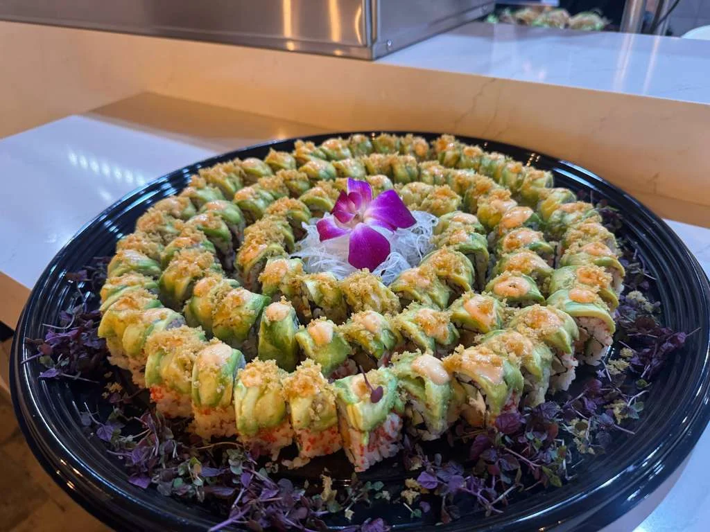 Artfully arranged sushi platter with avocado and decorative flower